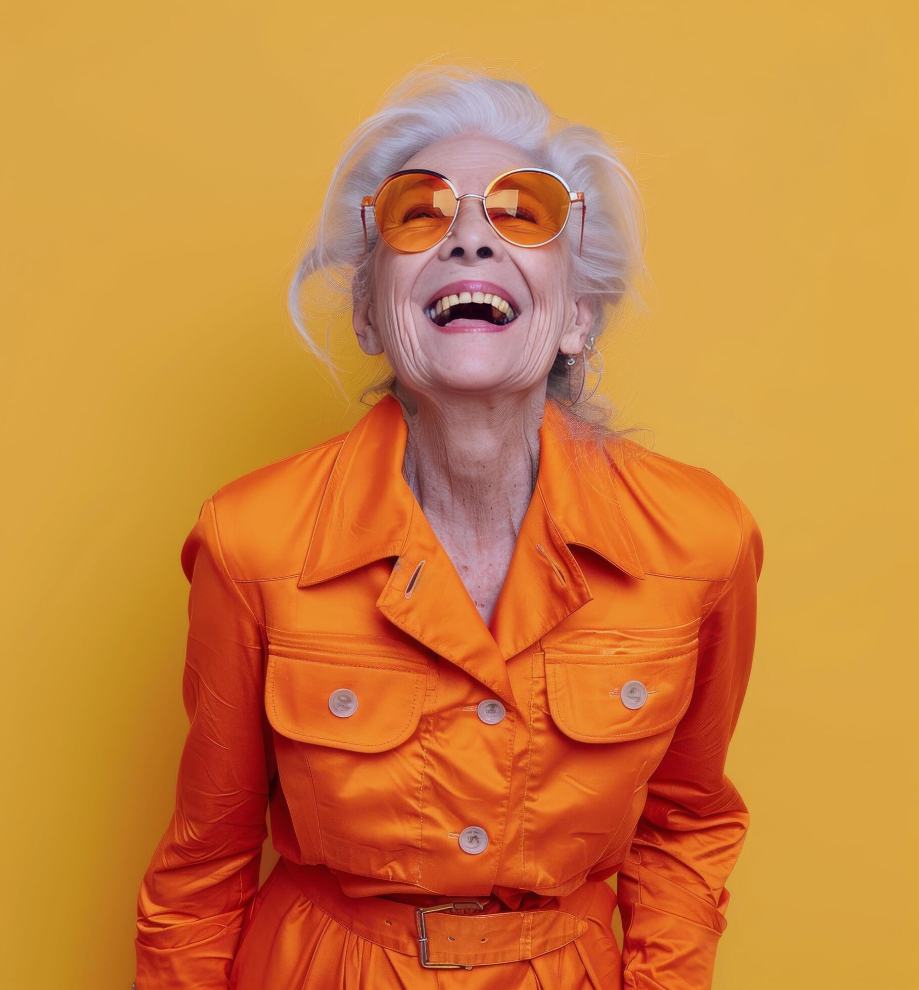 Smiling Senior Woman In Yellow Coat And Sunglasses Against Yellow Background Stock Free