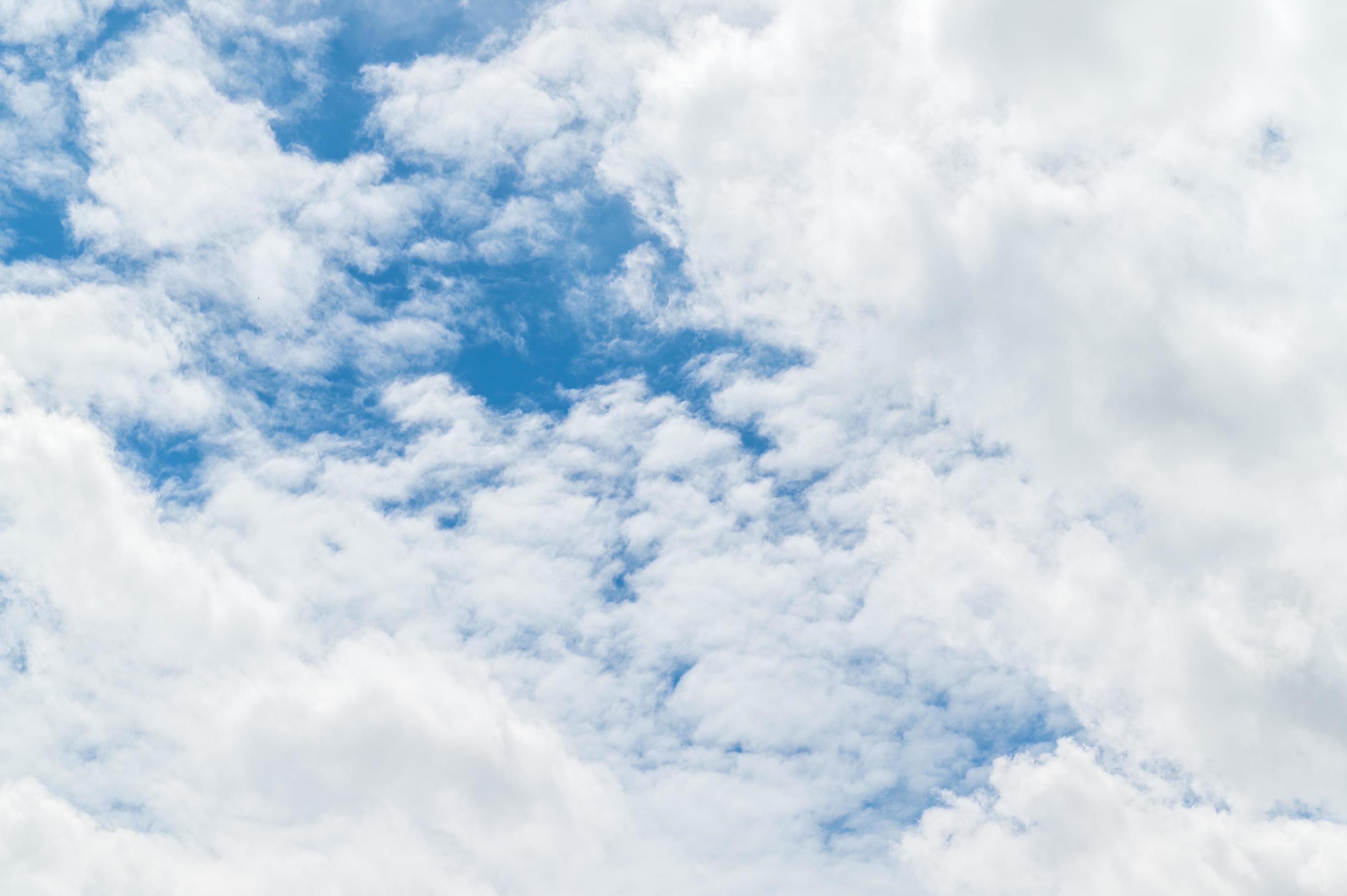 Nature background from white clouds in sunny day. Beautiful white fluffy clouds in blue sky. Stock Free