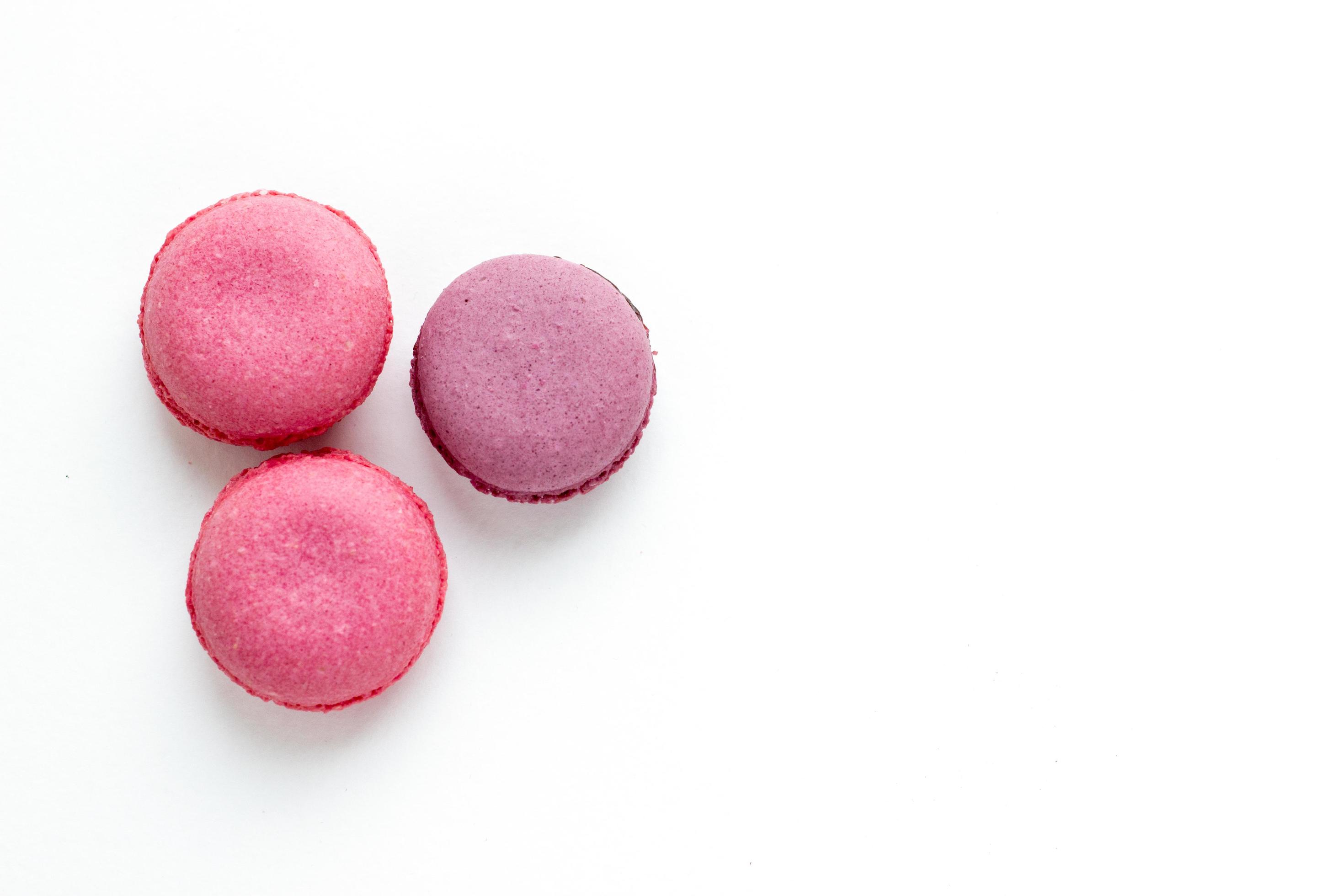 Bright macaroons on white background. Sweet food wallpaper with place for text. Stock Free