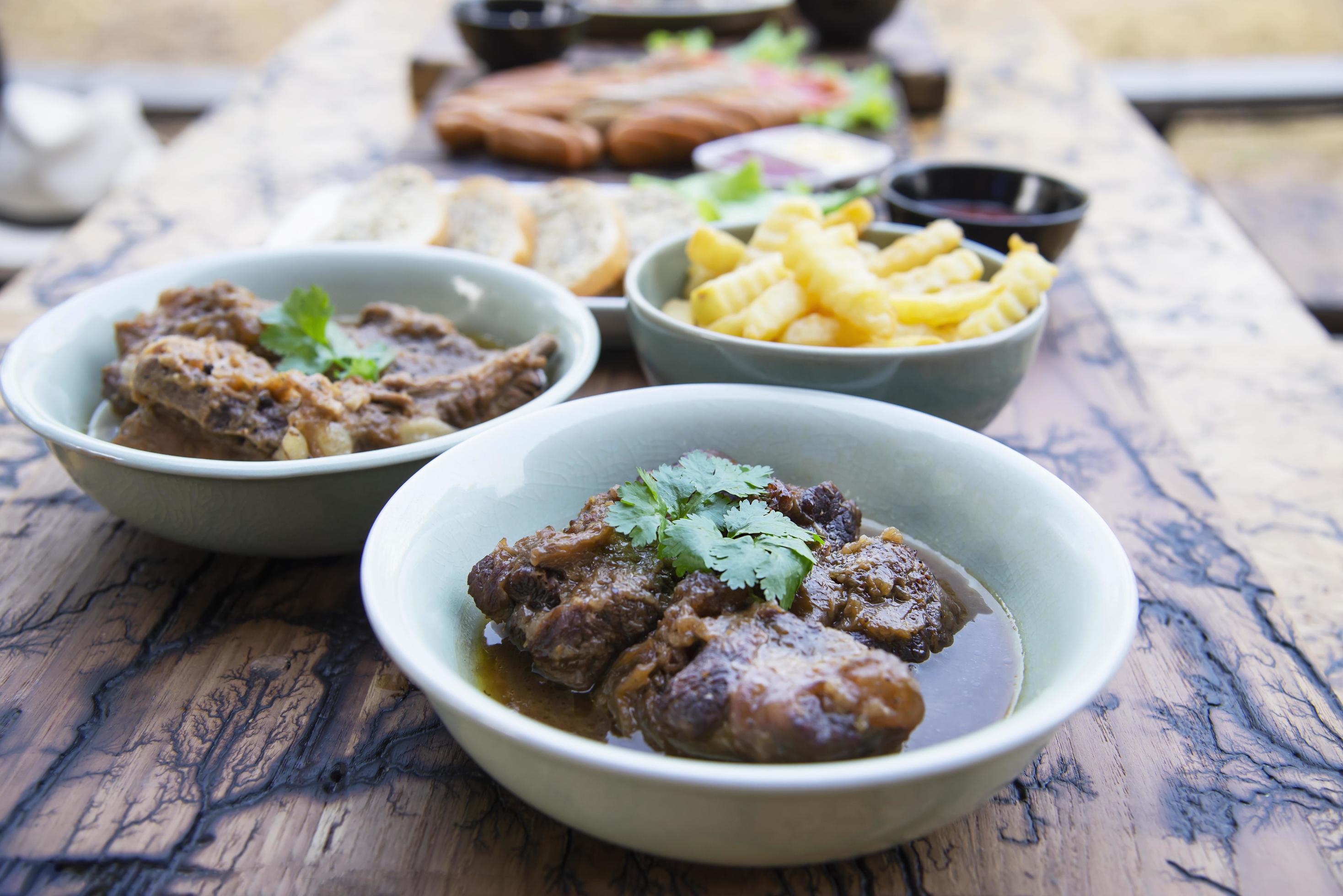 Beef and pork stew with French fries and others food recipes on wooden table, food meal preparing ready for eat concept Stock Free