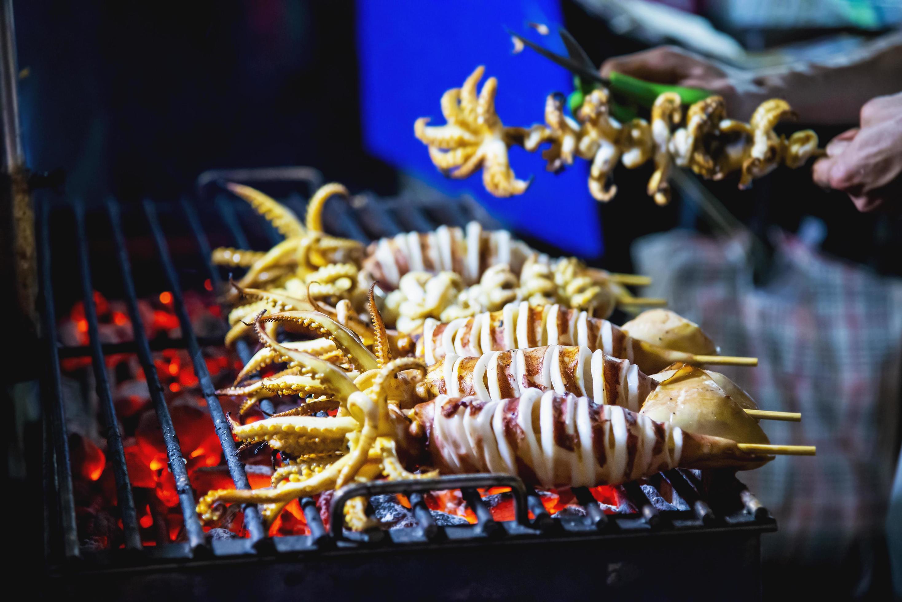 Grilled squid seller in local street food in Yaowarat road famous tourist place Thailand Stock Free