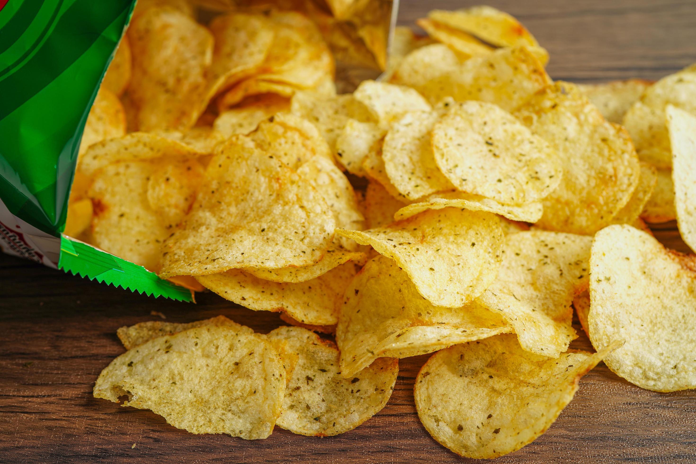 Potato chips in open bag, delicious BBQ seasoning spicy for crips, thin slice deep fried snack fast food in open bag. Stock Free