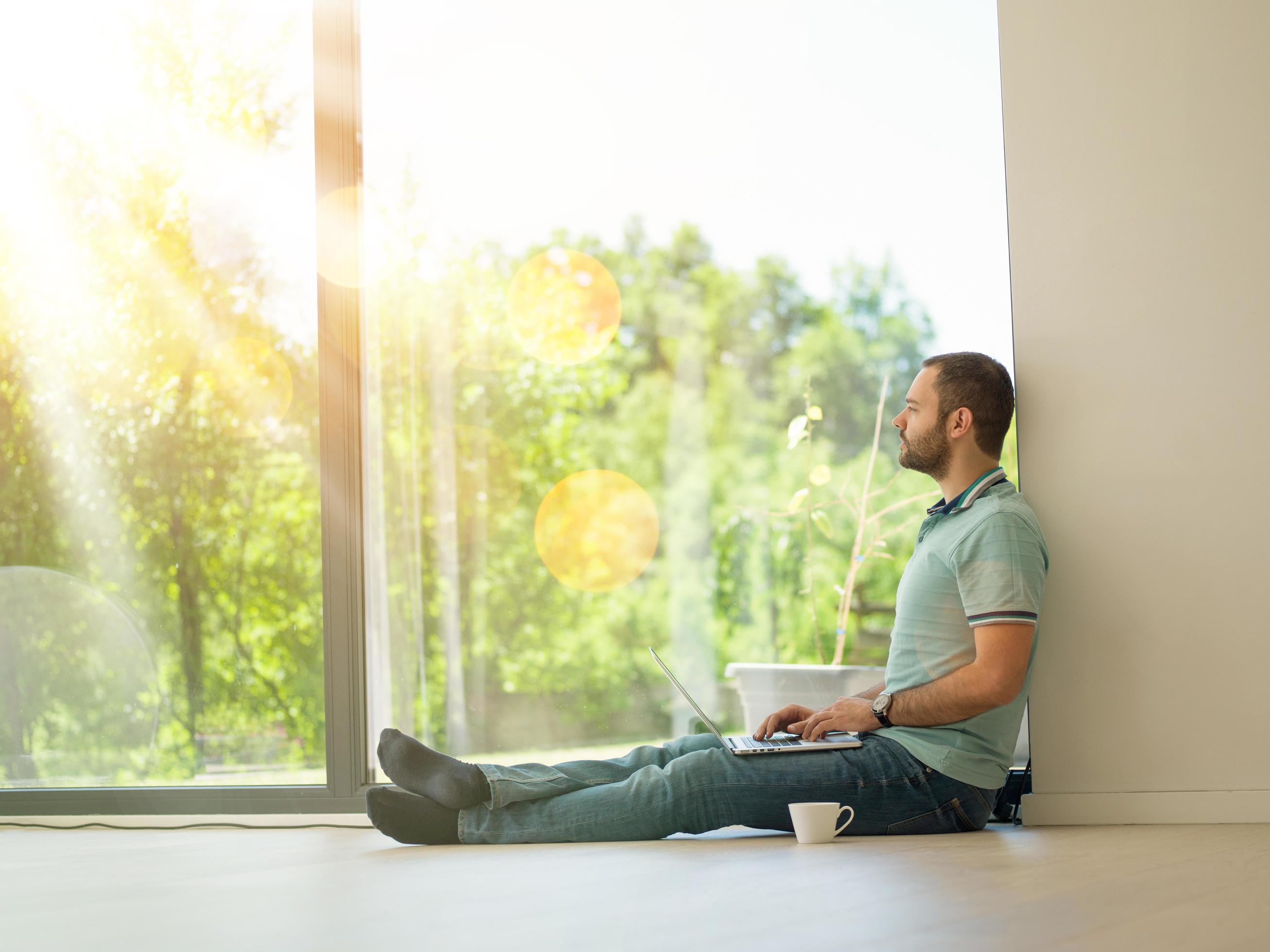 man drinking coffee on the floor enjoying relaxing lifestyle Stock Free