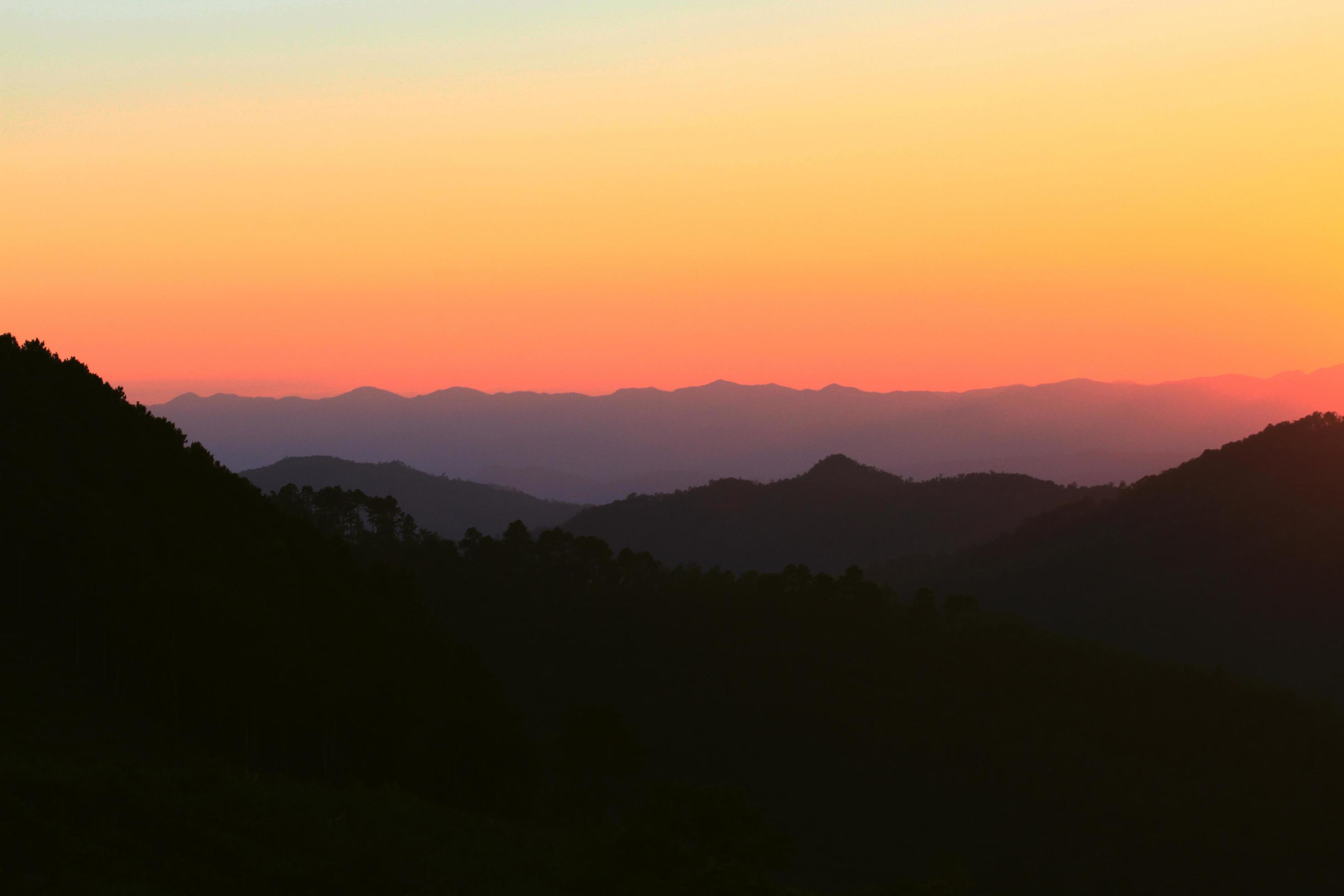 Sunset in sky and cloud, beautiful colorful twilight time with silhouette of mountain. Stock Free