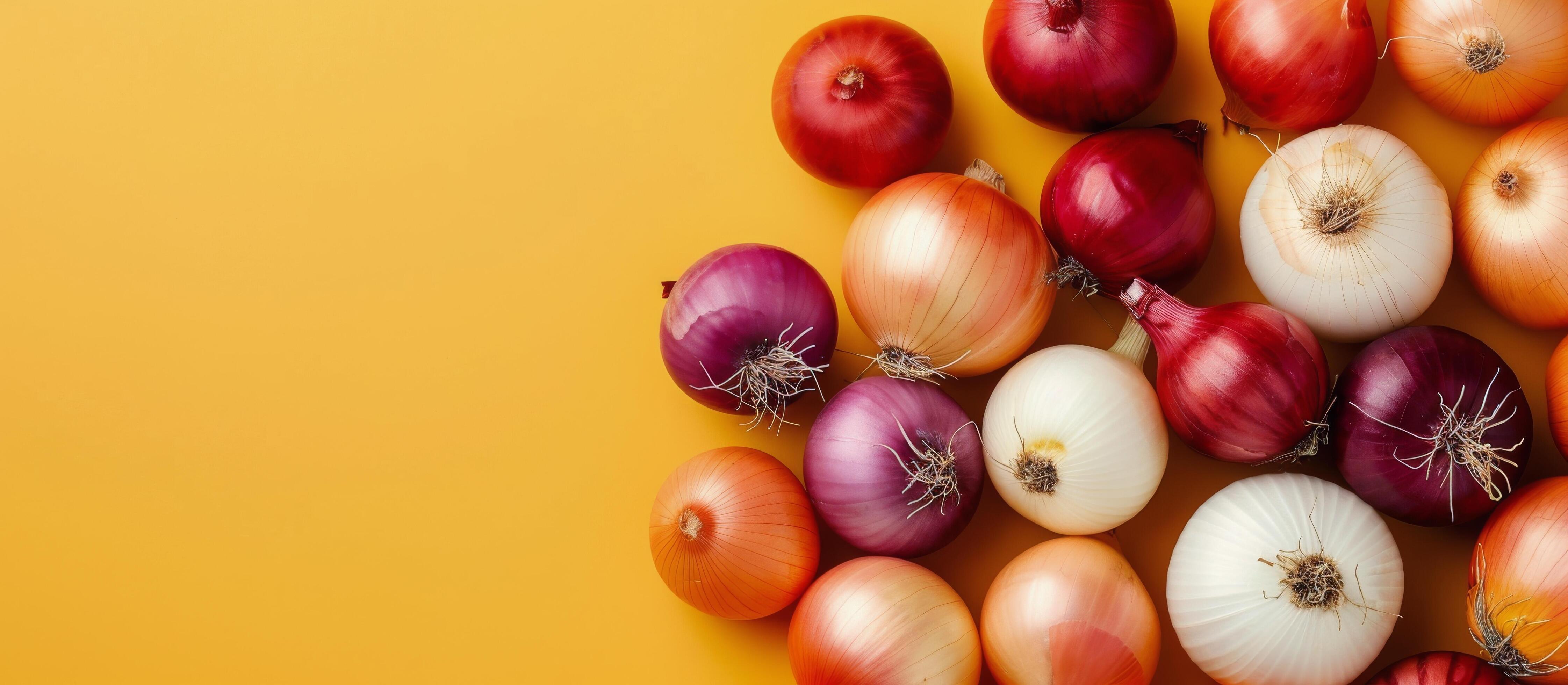 Variety of Fresh Onions on Yellow Background Stock Free