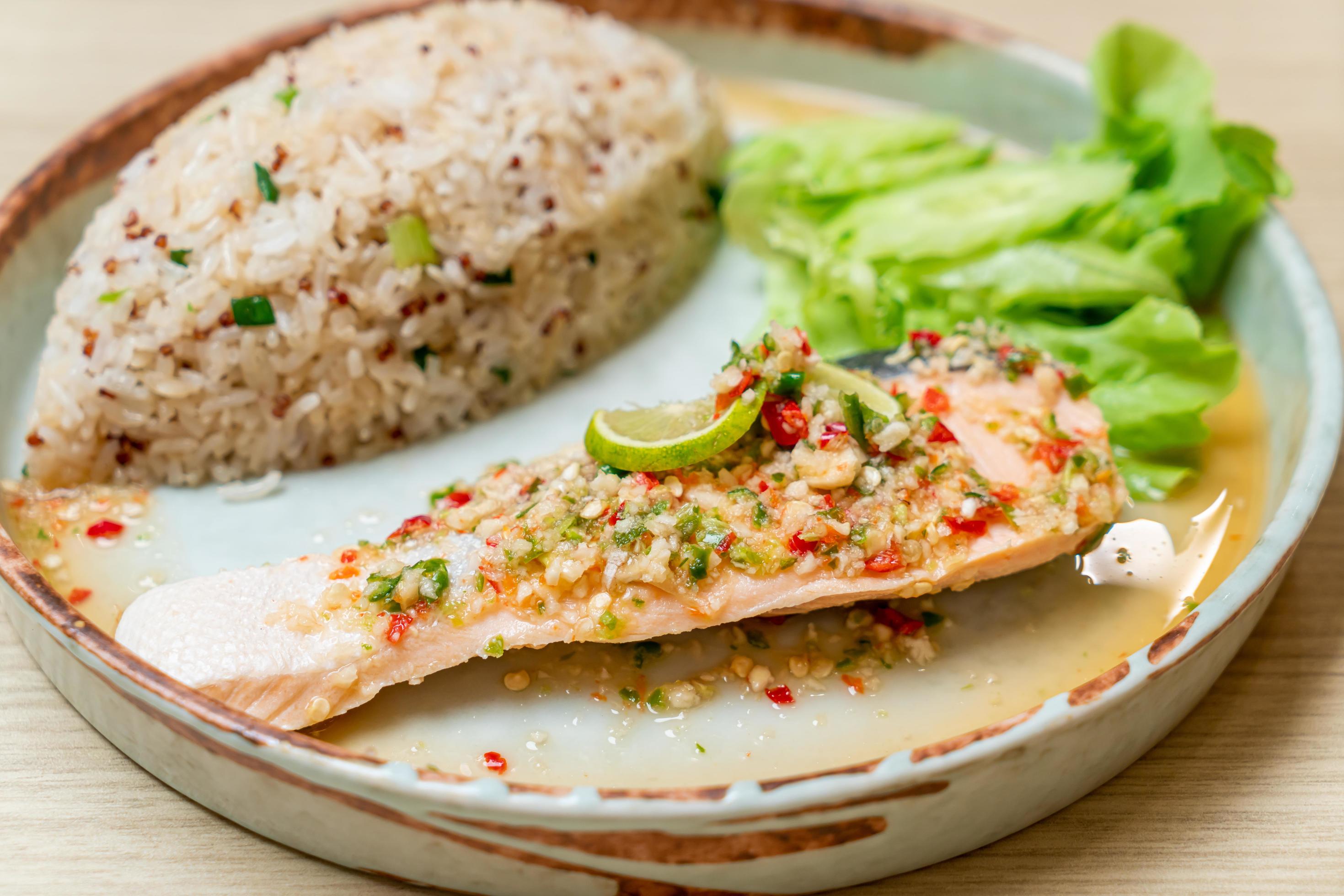 Quinoa fried rice with steamed salmon in lime chili dressing – healthy food style Stock Free