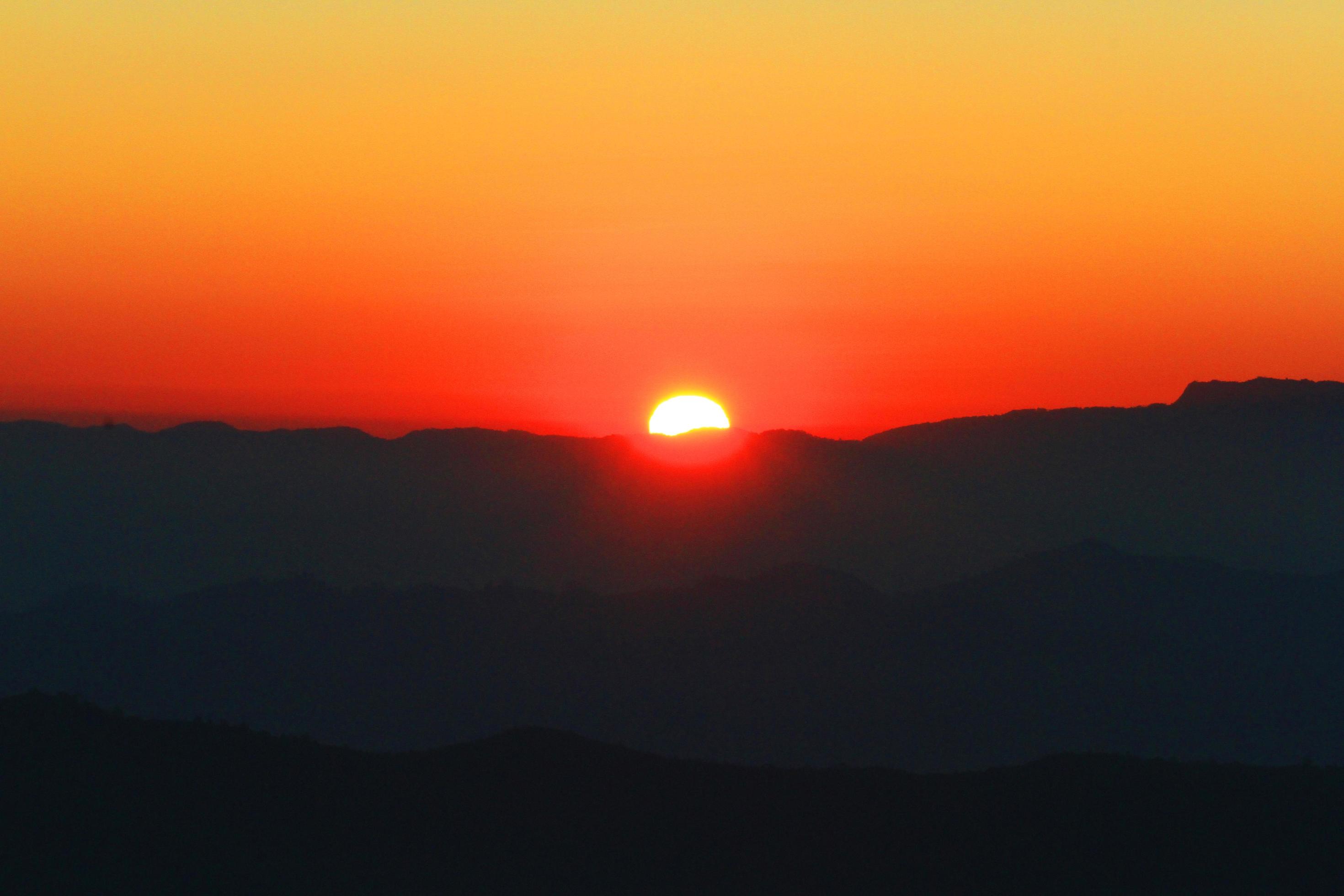 Sunset in sky and cloud, beautiful colorful twilight time with silhouette of mountain. Stock Free