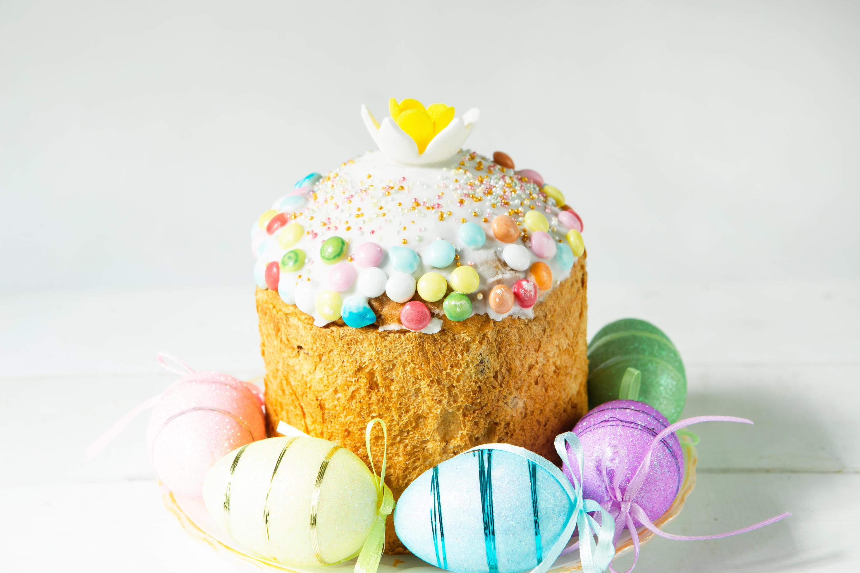 Easter cake with painted eggs on a platter in a gray interior. Traditional festive food Stock Free