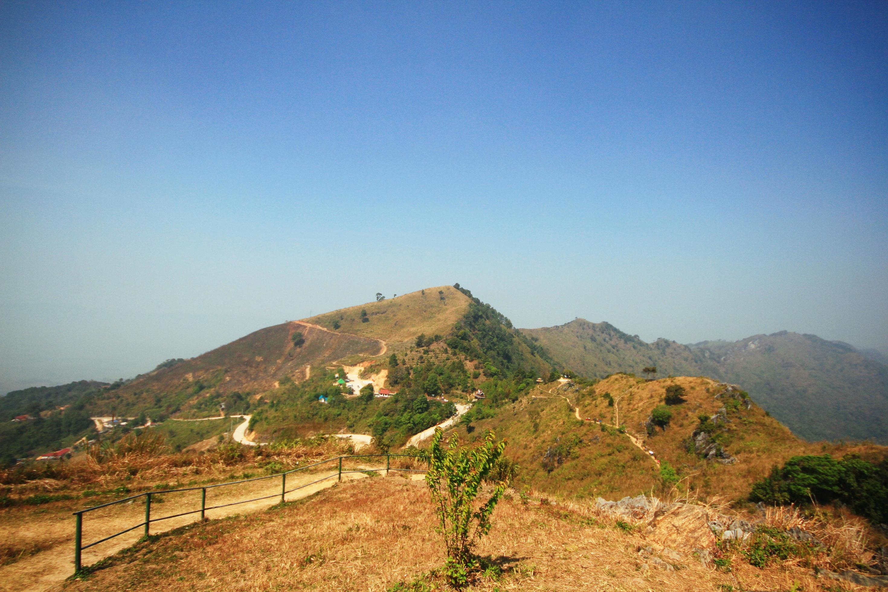 Dry grassland and wild with blue sky on the valley mountain at Doi Pha Tang hill in Thailand Stock Free