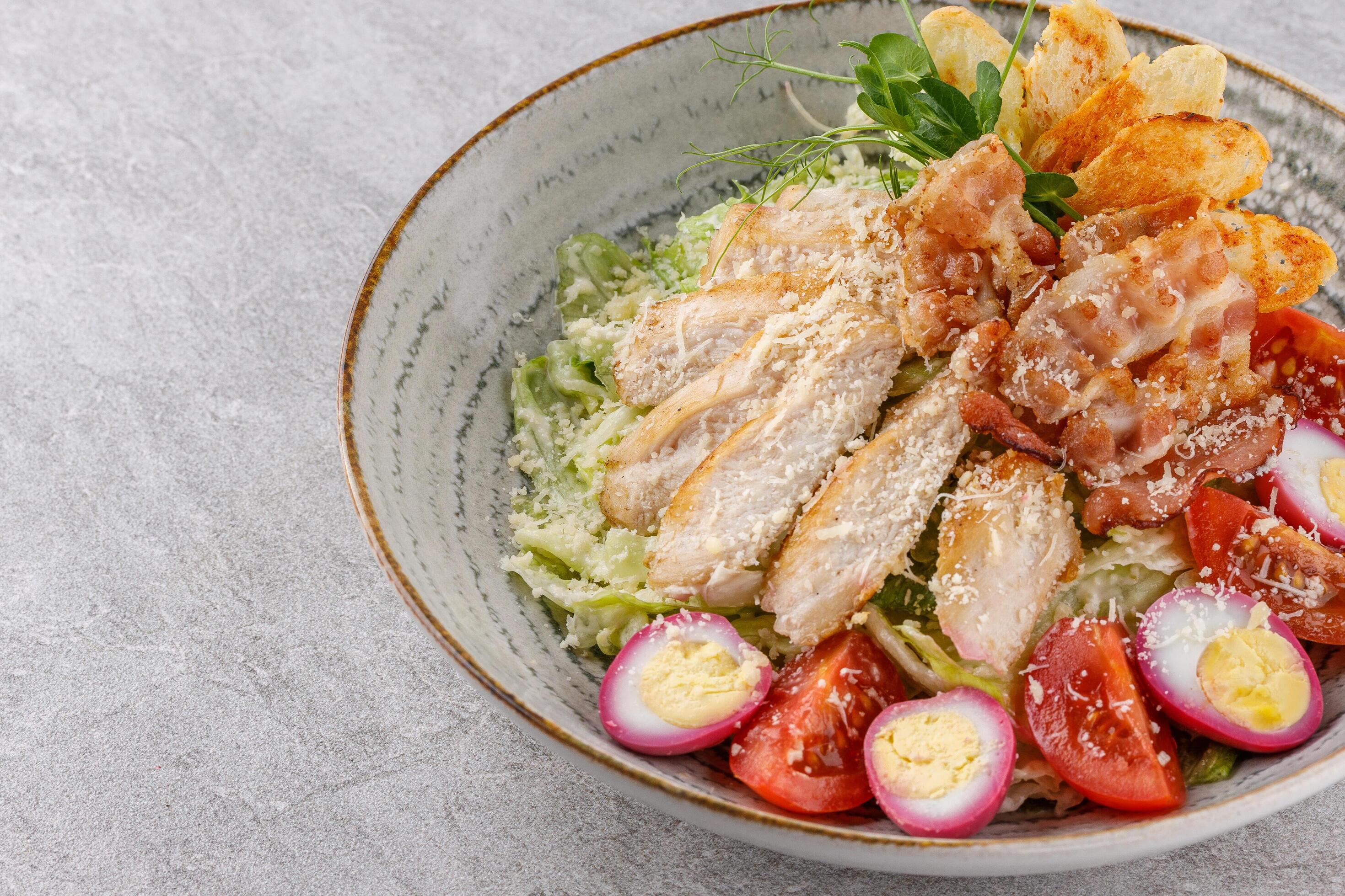 Caesar salad with chicken and bacon on a stone background studio food photo6 Stock Free