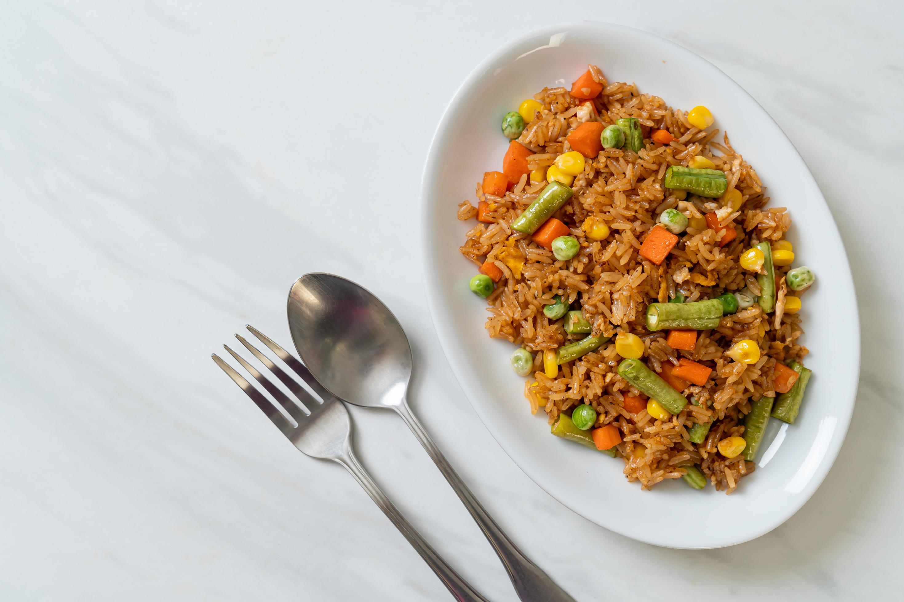 Fried rice with green peas, carrots, and corn – vegetarian and healthy food style Stock Free