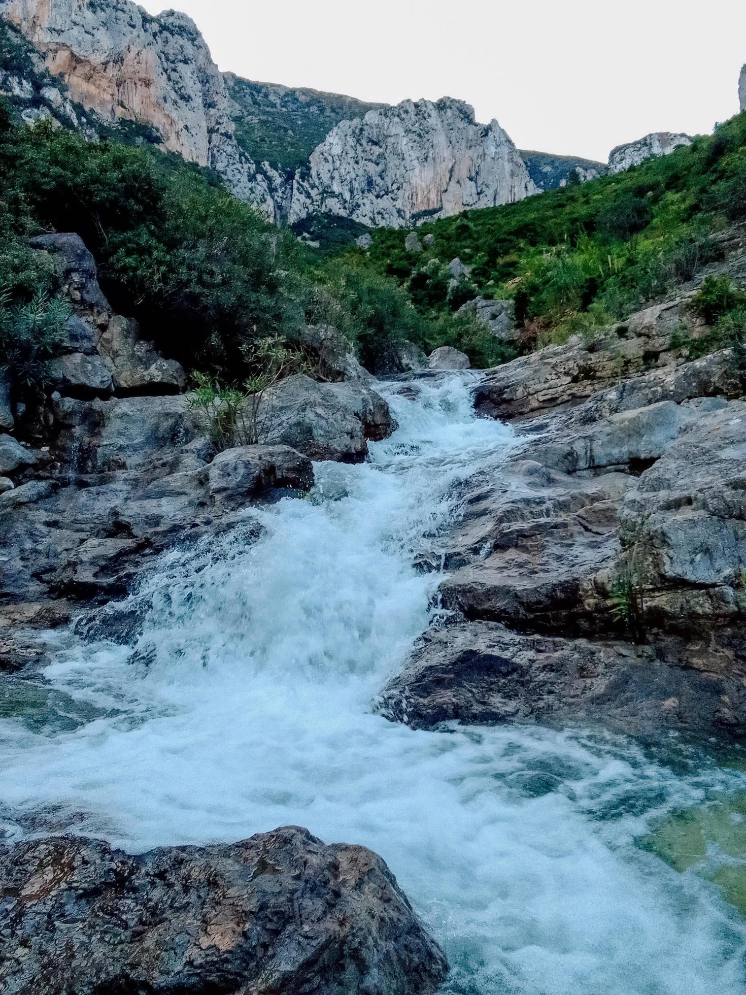 Uncover the serene beauty of a small waterfall nestled at the foot of a mountain a journey through the heart of nature tranquil splendor Stock Free