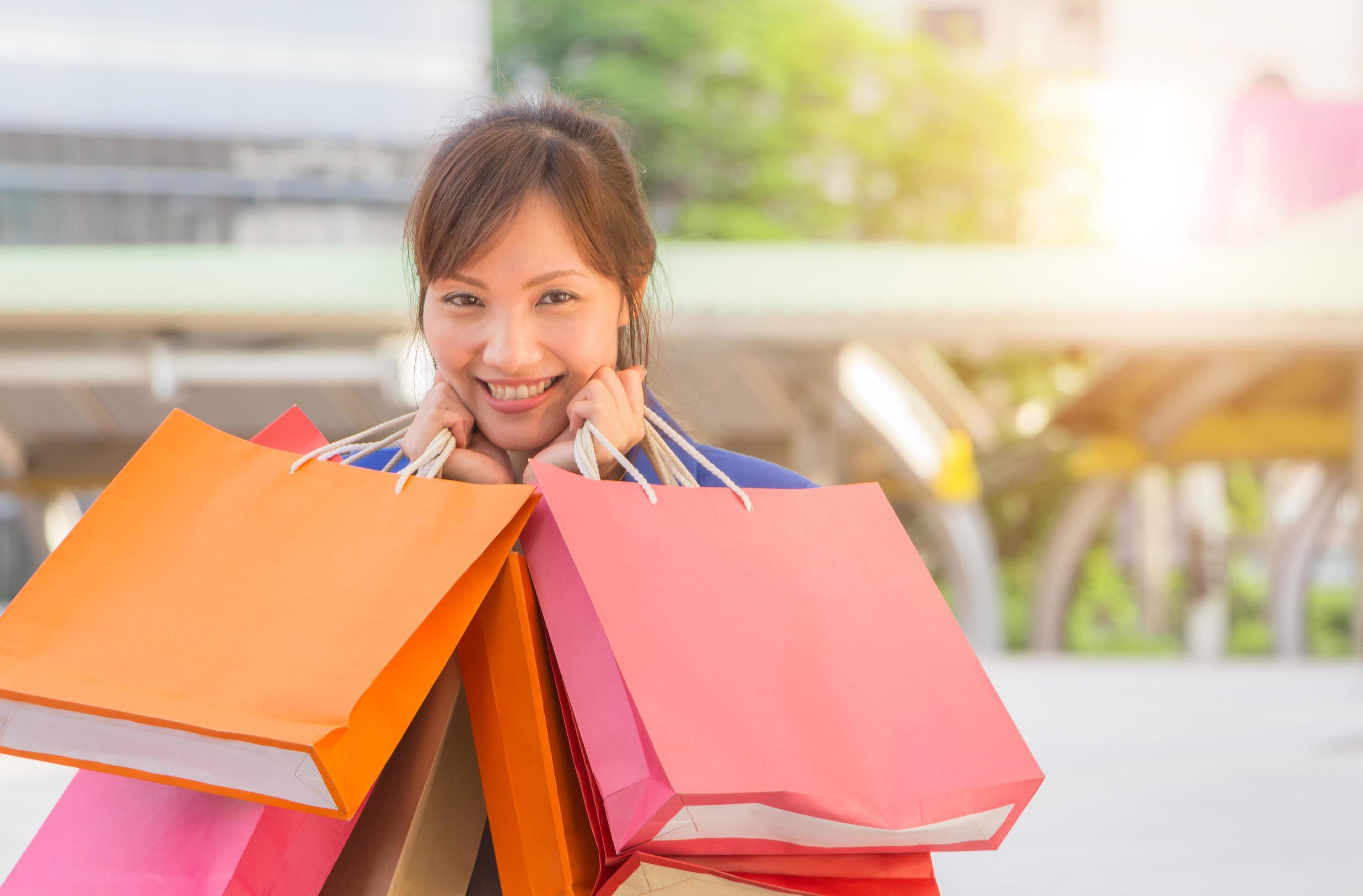 young woman carrying shopping bags while walking along the street. Happy Life Style Concept. Stock Free