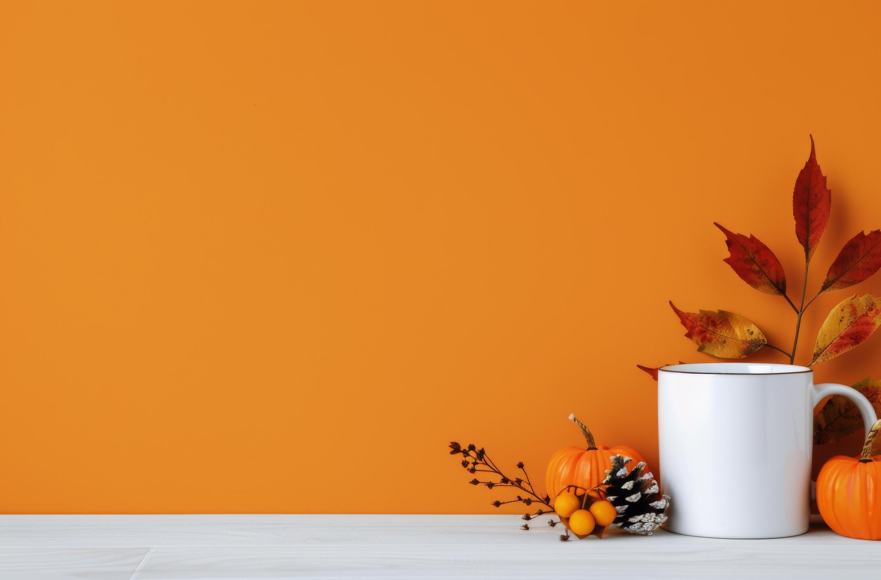 White Mug With Fall Leaves on Orange Background Stock Free