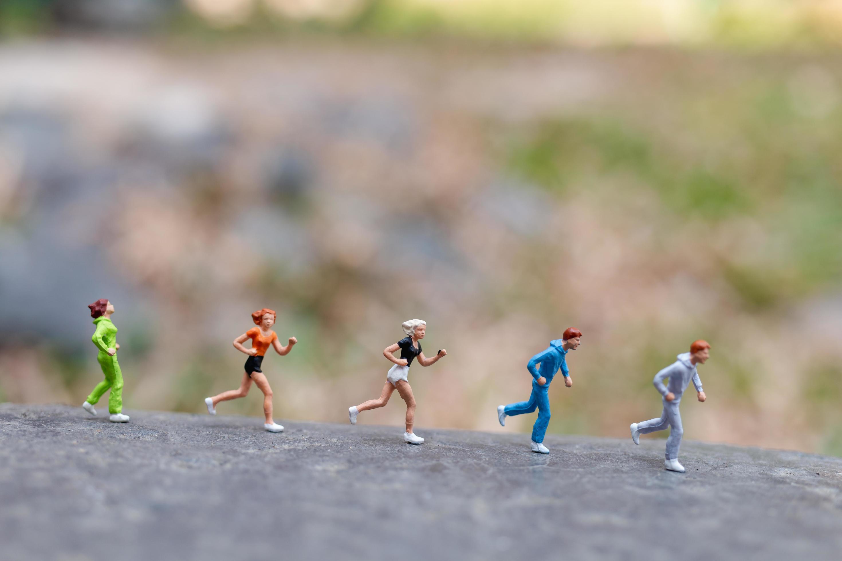 Miniature people running on a rock, health and lifestyle concept Stock Free