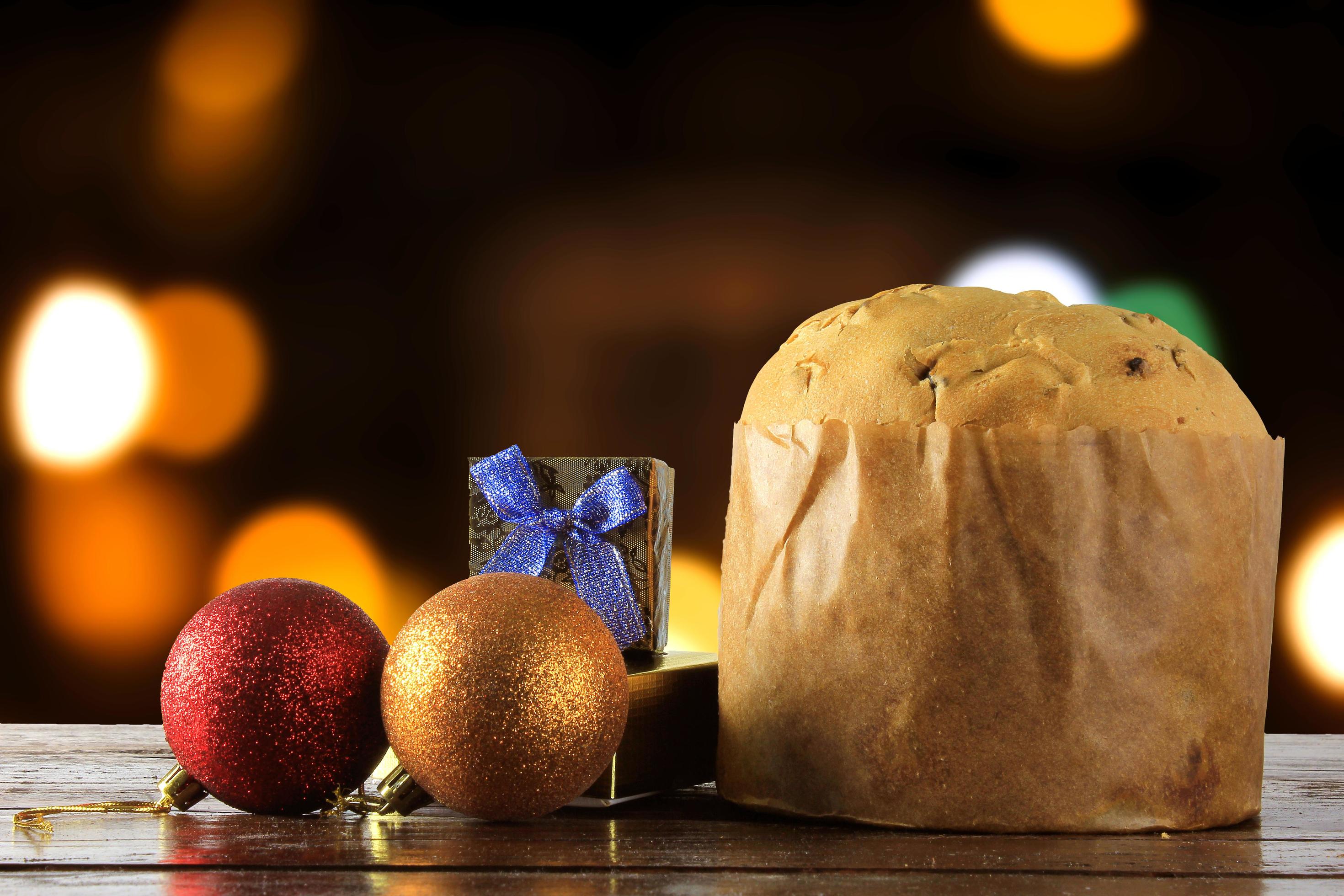 panettone, decorative food, on wooden table, blurred lights in the background Stock Free