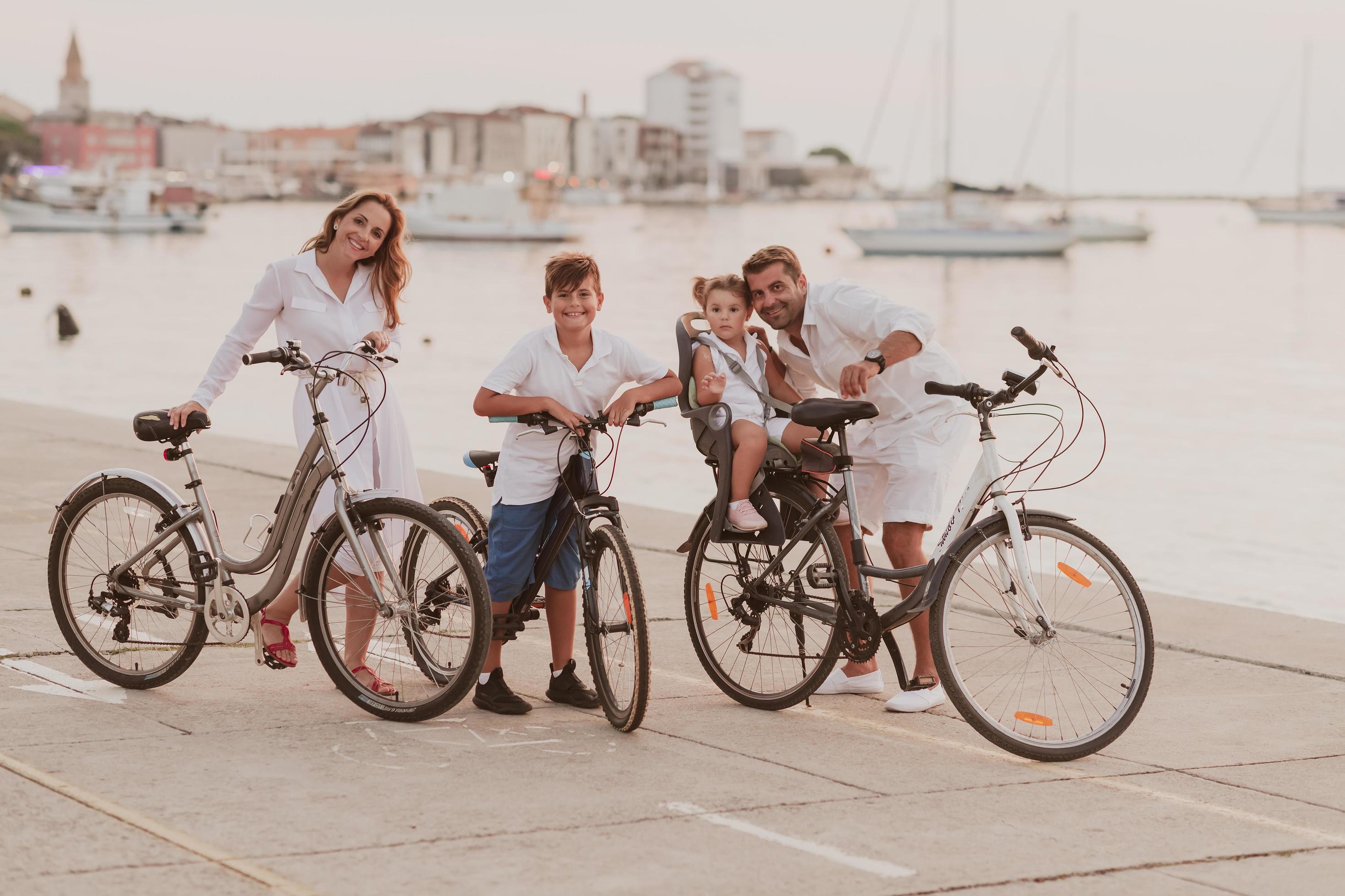 The happy family enjoys a beautiful morning by the sea riding a bike together and spending time together. The concept of a happy family Stock Free