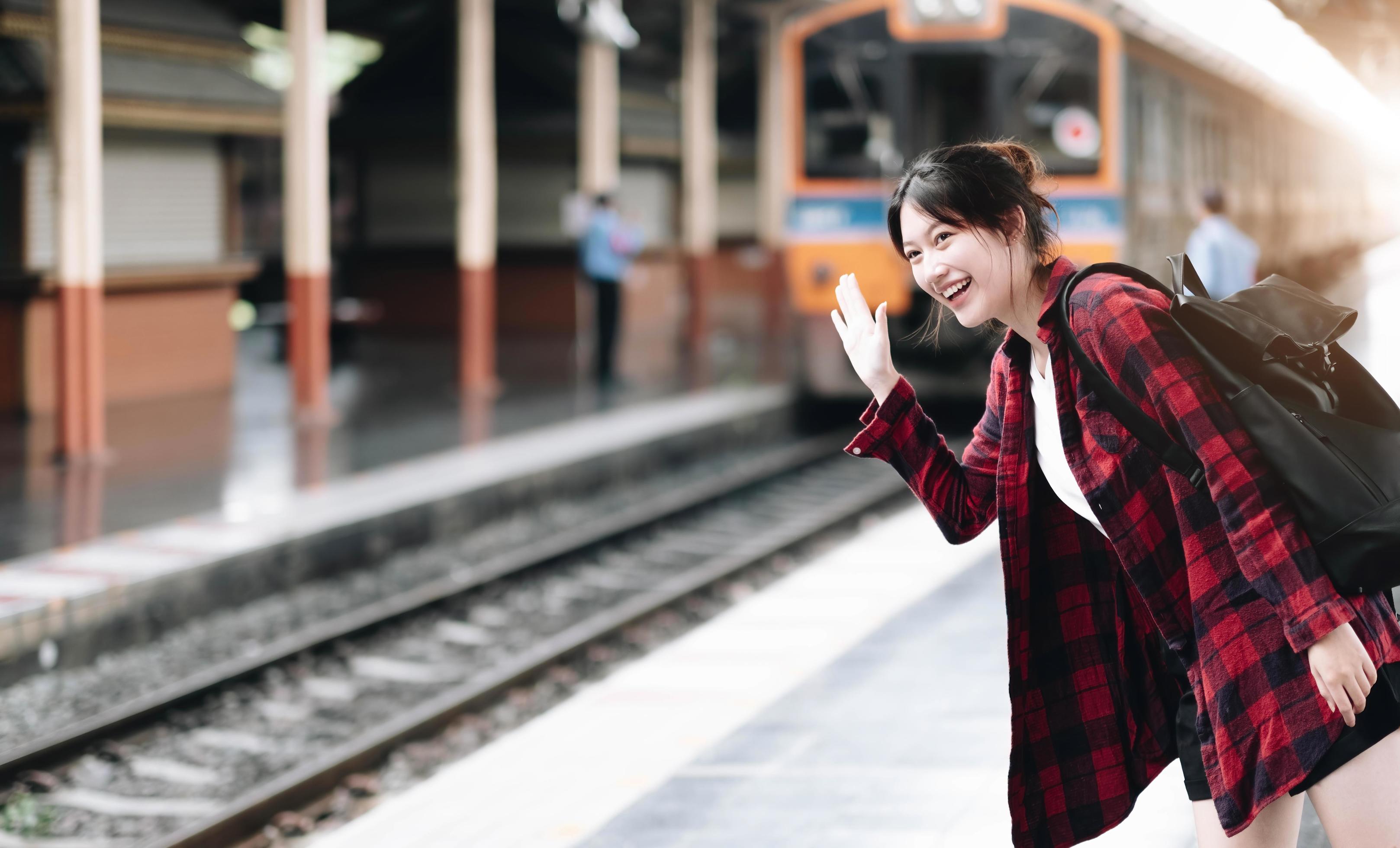 Young traveler woman looking for friend planning trip at train station. Summer and travel lifestyle concept Stock Free