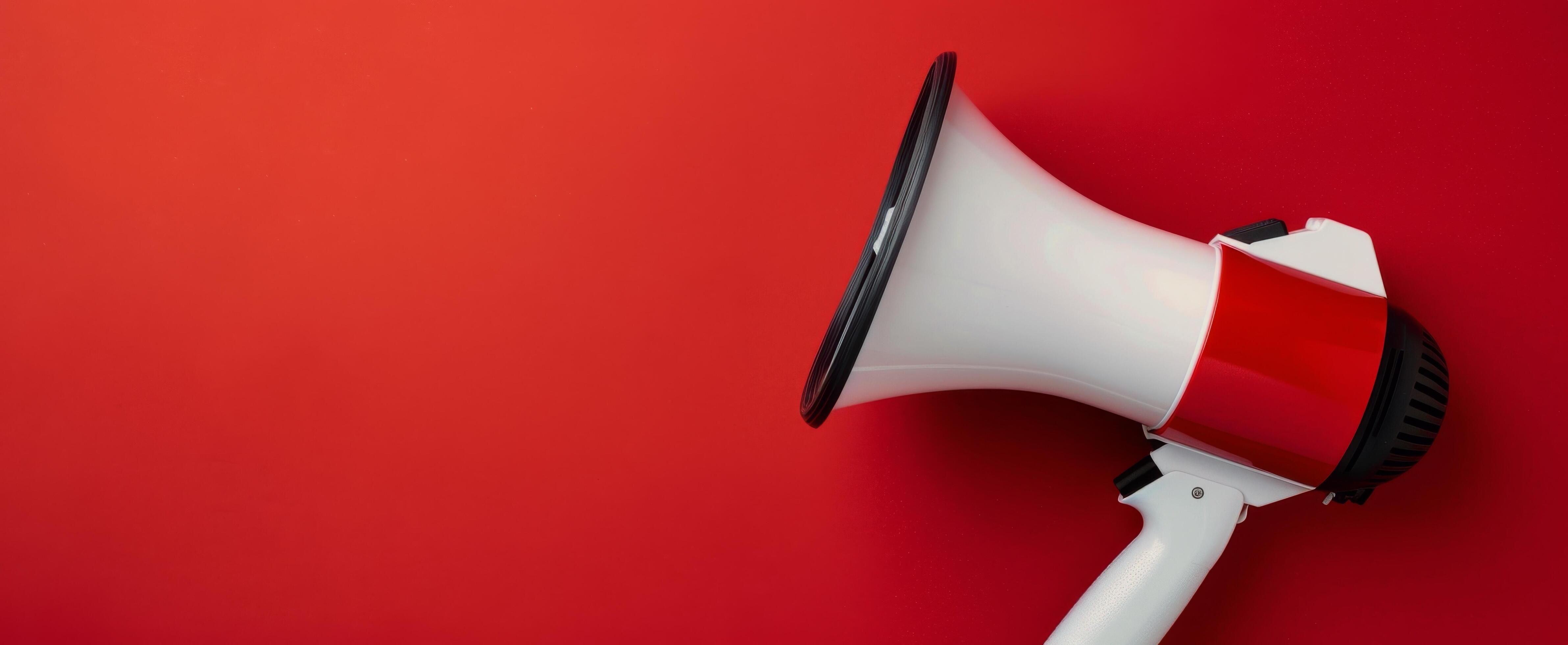 Megaphone Positioned on Red Background for Announcements and Communication Stock Free