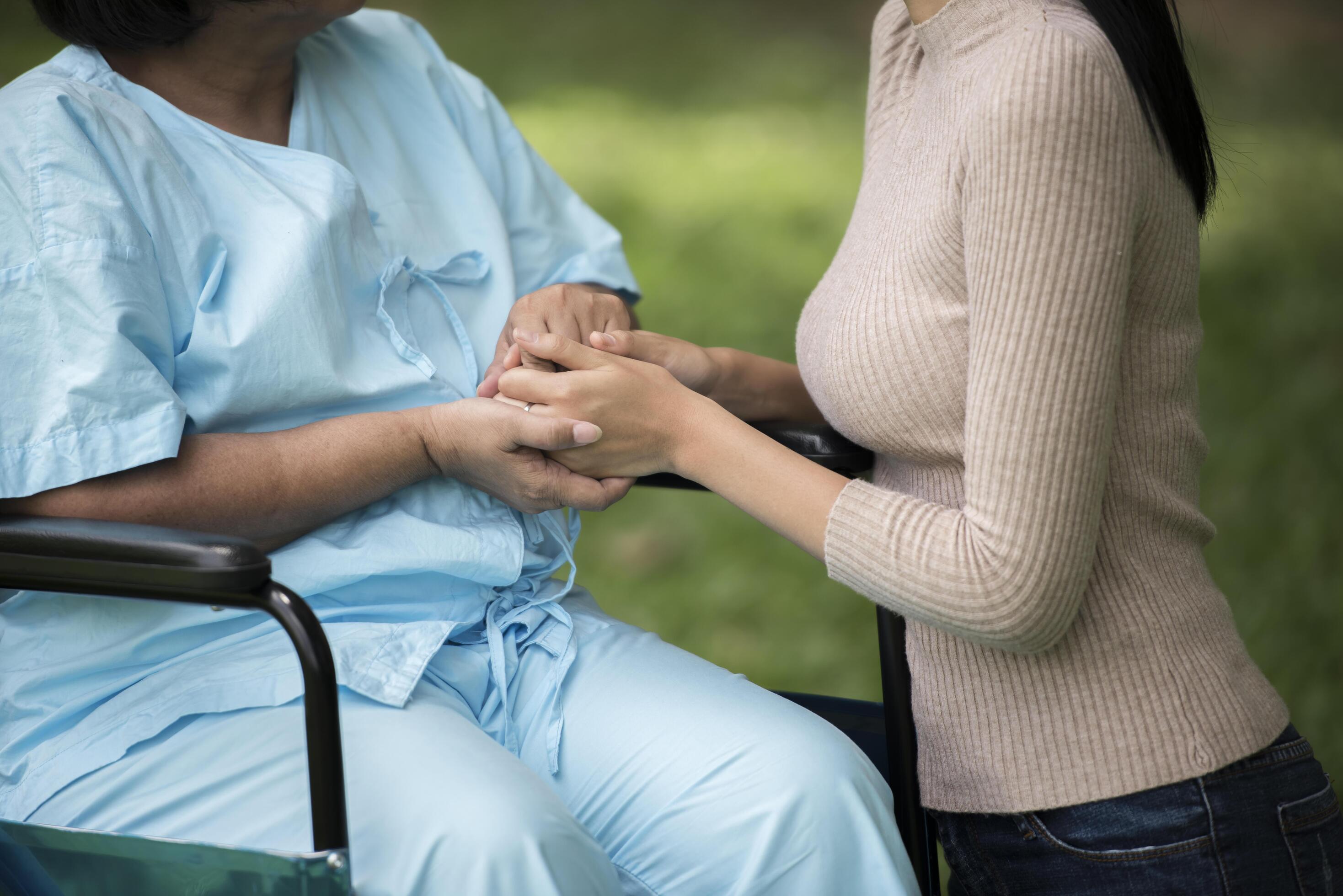 Granddaughter talking with her grandmother sitting on wheelchair, cheerful concept, happy family Stock Free