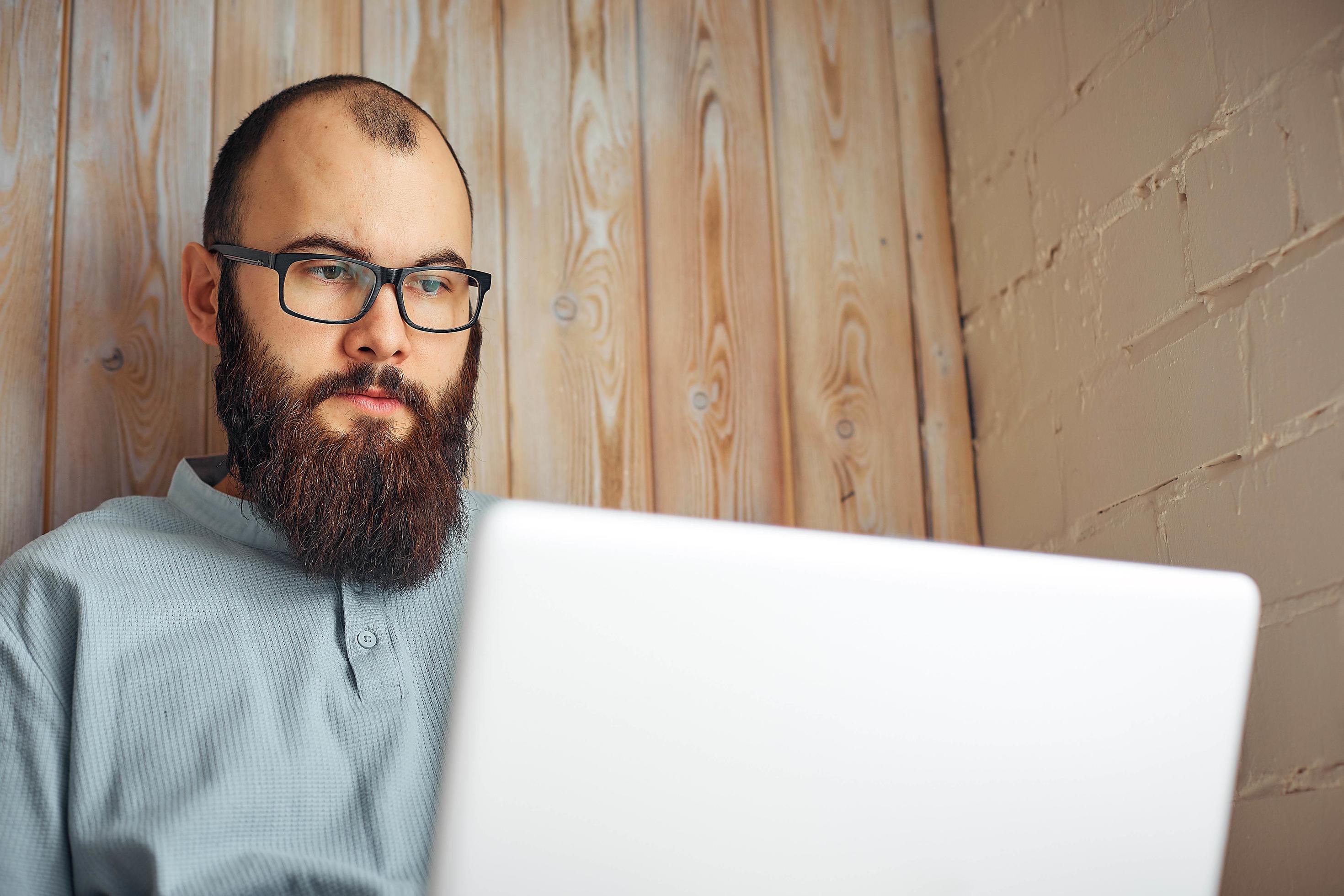 lifestyle successful freelancer man with beard achieves new goal with laptop in loft interior. Stock Free