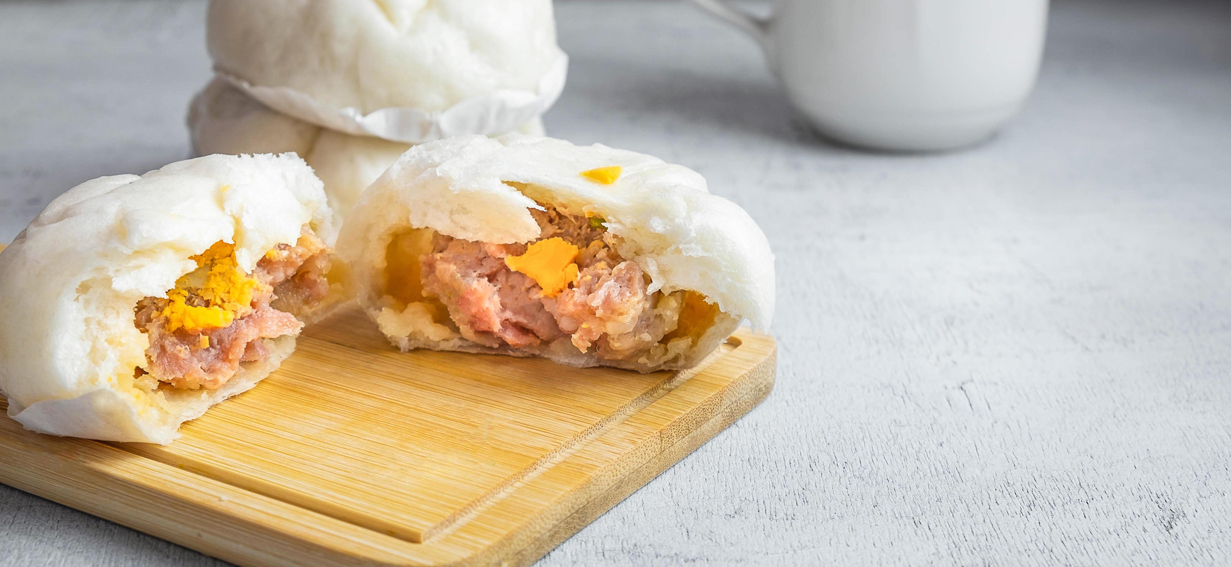 The Chinese food menu of Steamed Buns split in the middle reveals Pork Belly on white table Stock Free