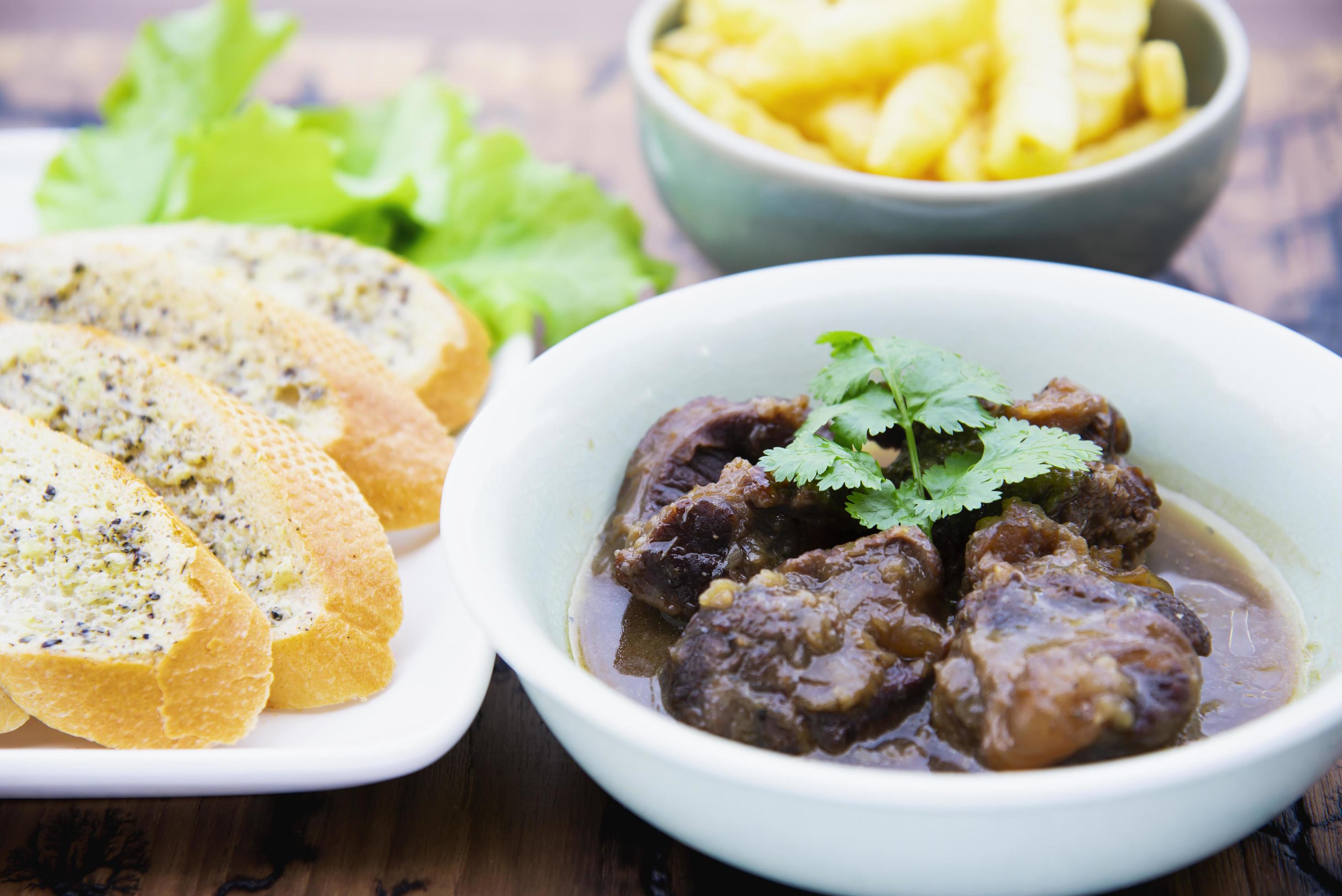 Beef and pork stew with French fries and others food recipes on wooden table, food meal preparing ready for eat concept Stock Free