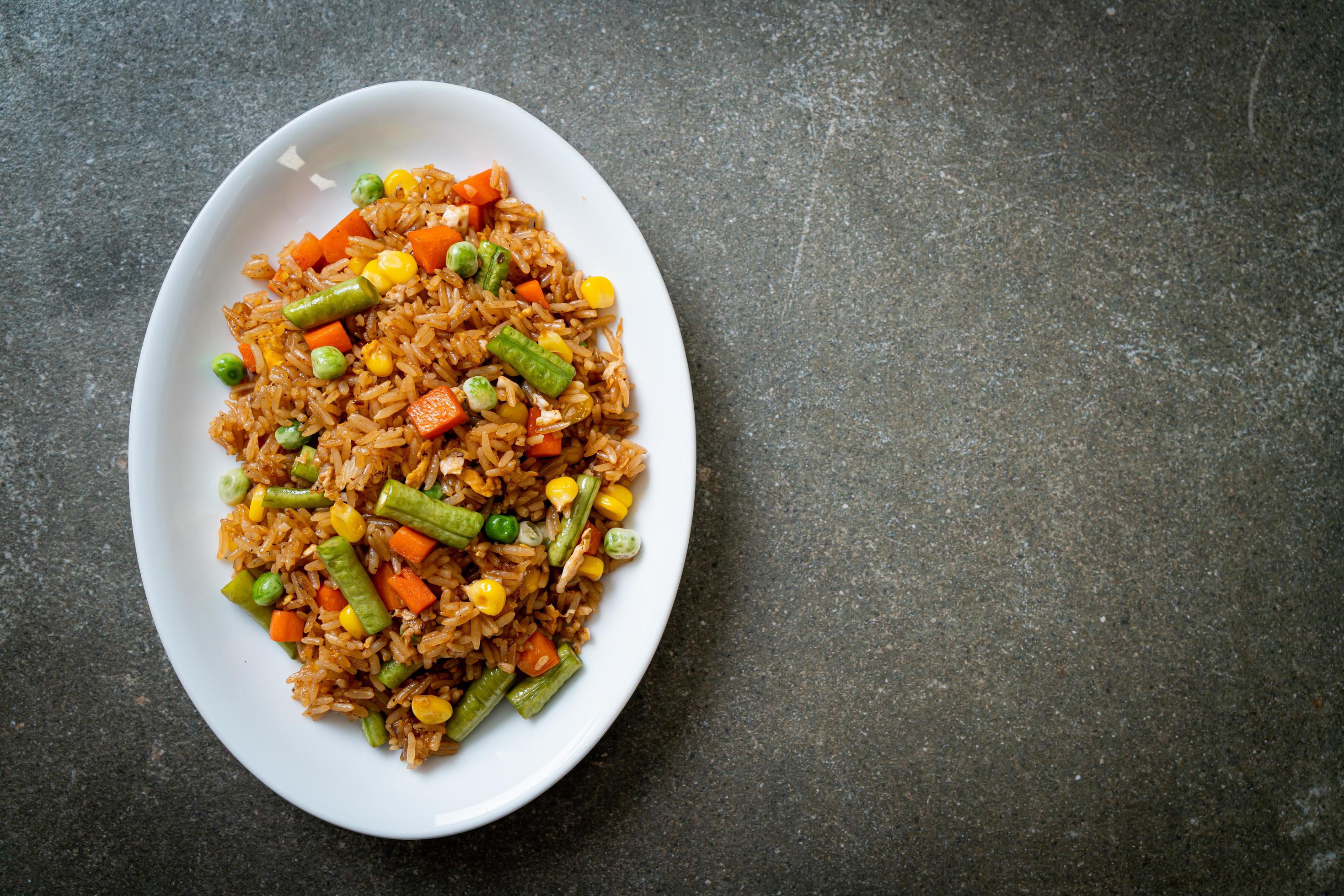 Fried rice with green peas, carrots, and corn – vegetarian and healthy food style Stock Free