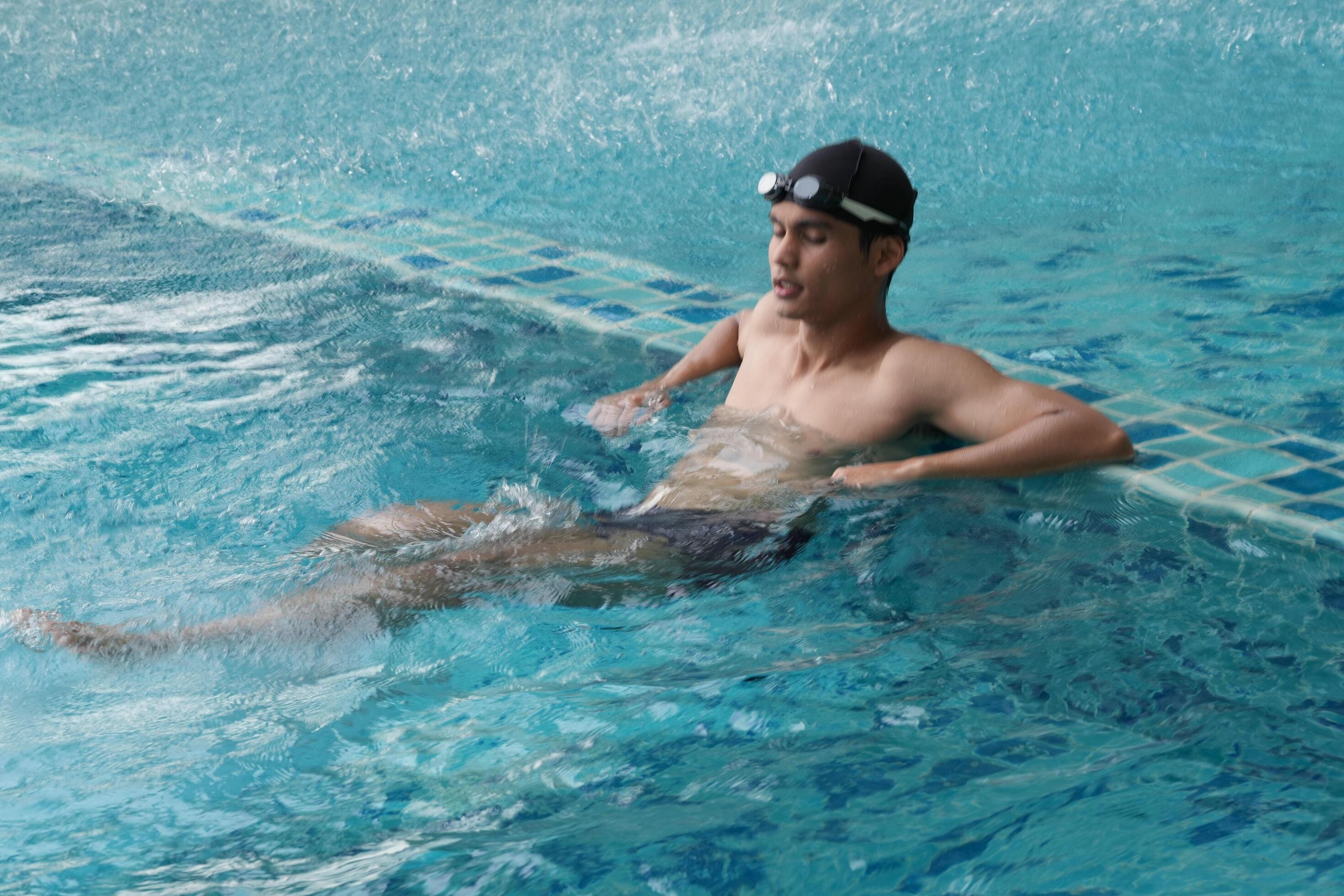 Asian men practicing swimming and preparing to play water polo and stretching and resting for water sports. Stock Free