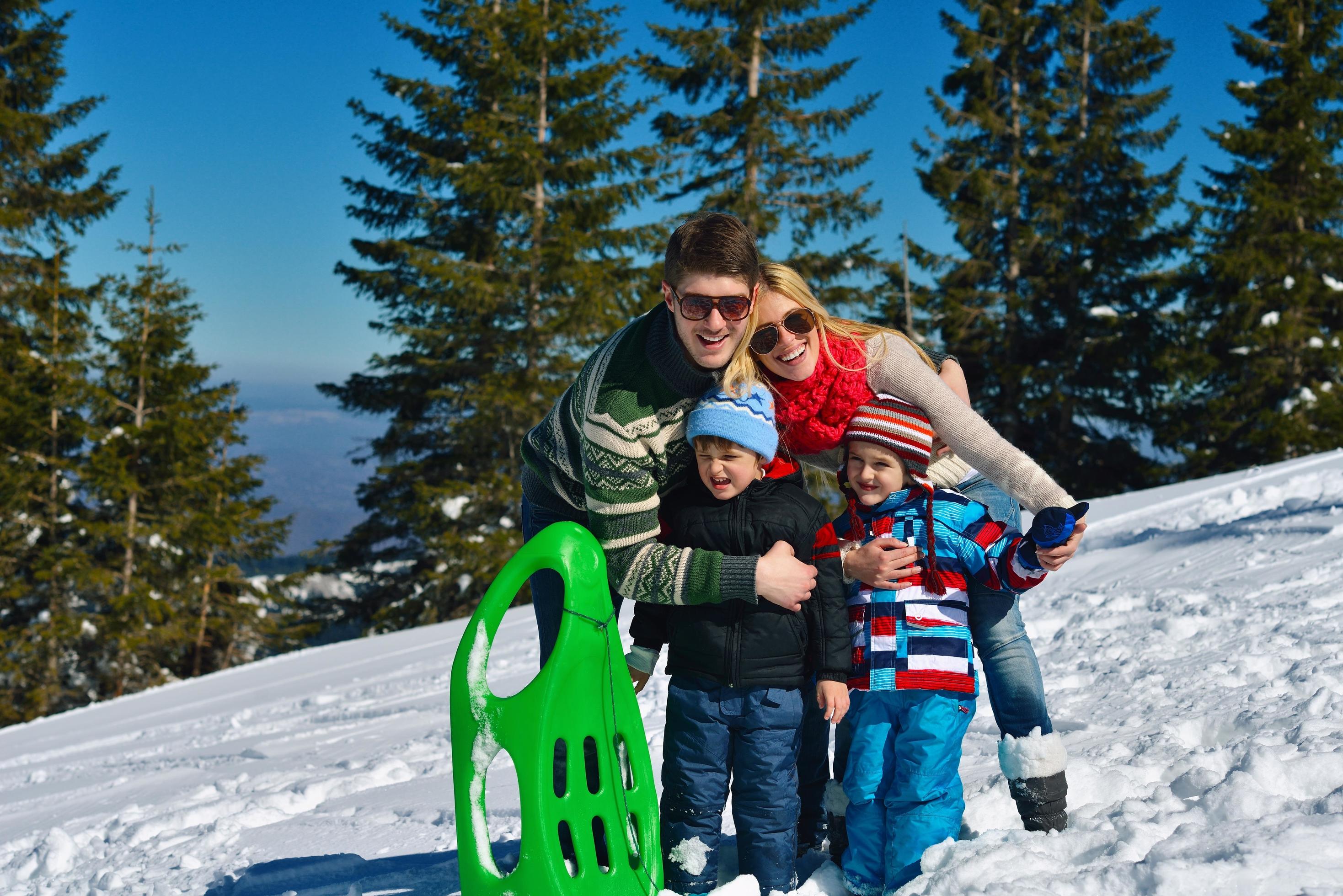 family having fun on fresh snow at winter vacation Stock Free