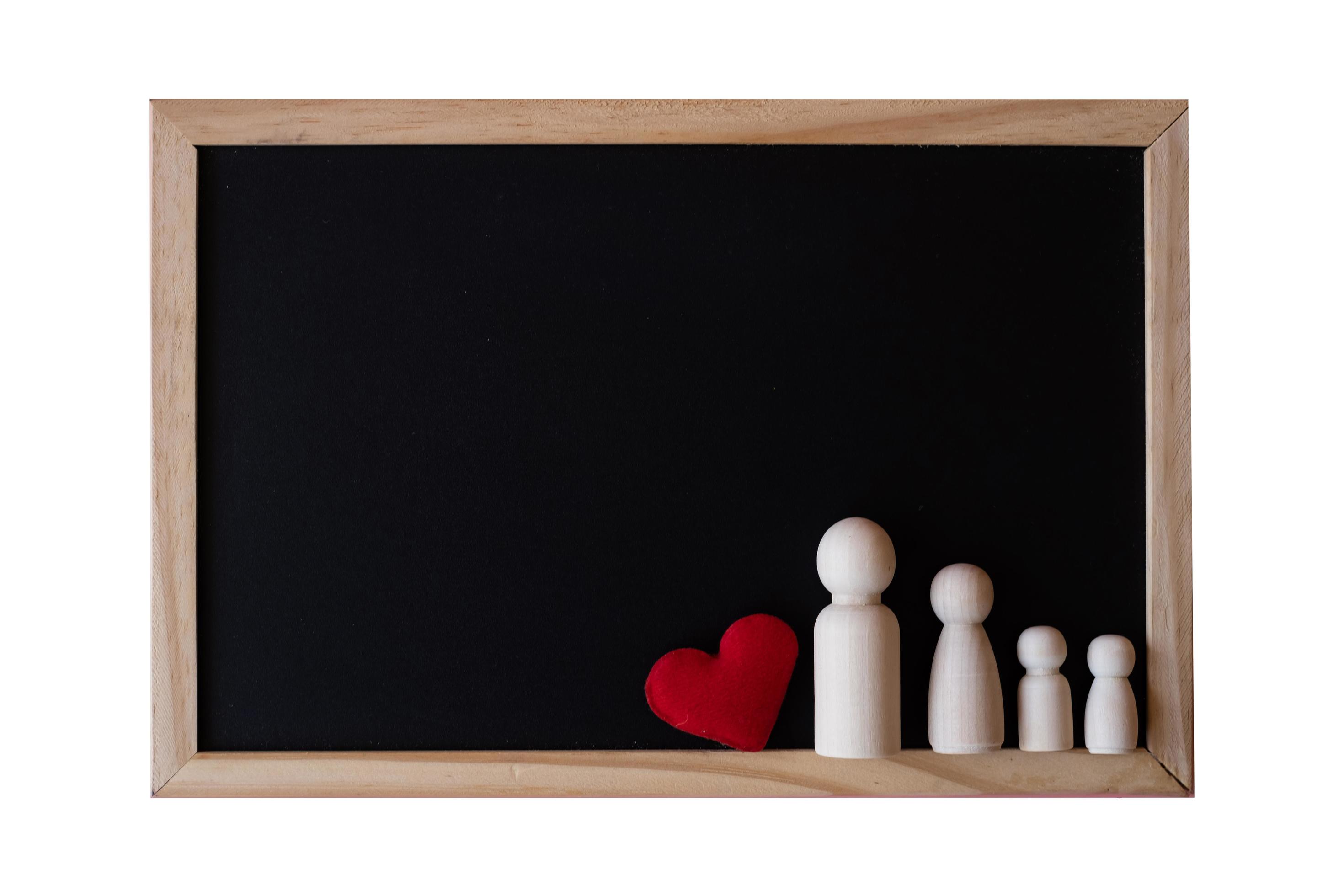 Wooden figurines of family father, mother and children on the black board on white background. copy space for text. Stock Free