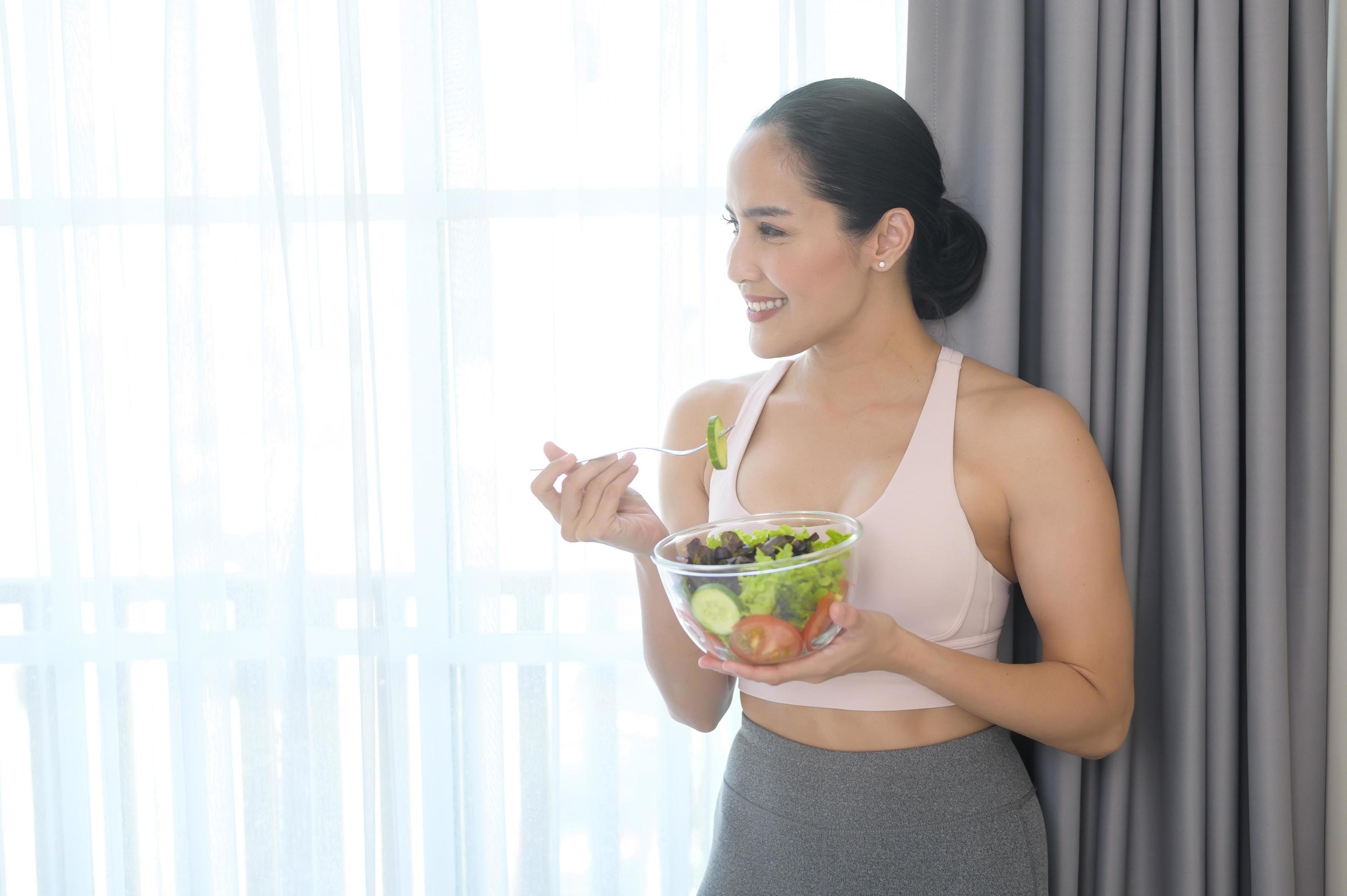 
									Fit young woman having salad after work out at home, sport and healthy lifestyle concept. Stock Free