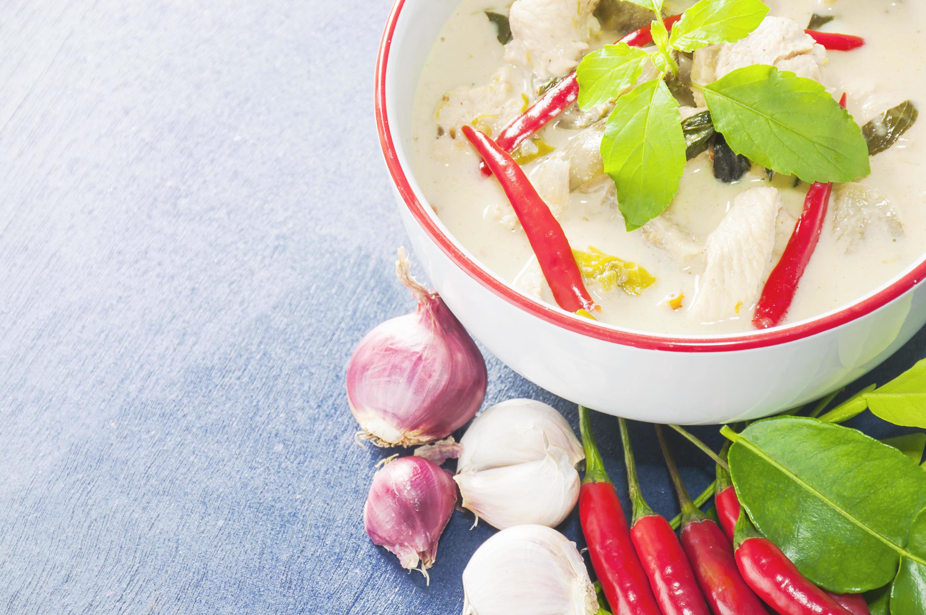 Green chicken curry with raw spicy ingredient Thai traditional food on light blue background Stock Free