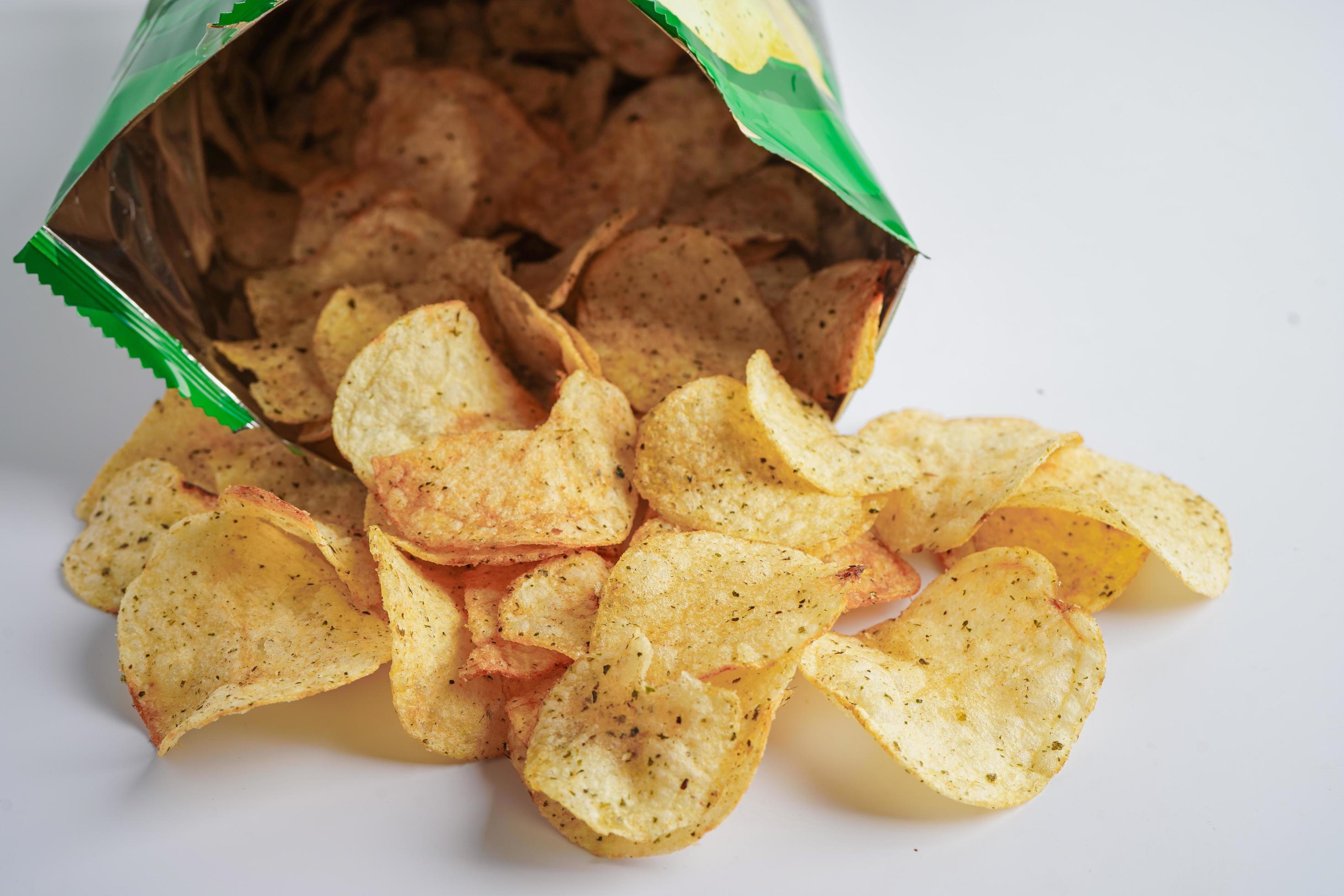 Potato chips in open bag, delicious BBQ seasoning spicy for crips, thin slice deep fried snack fast food in open bag. Stock Free