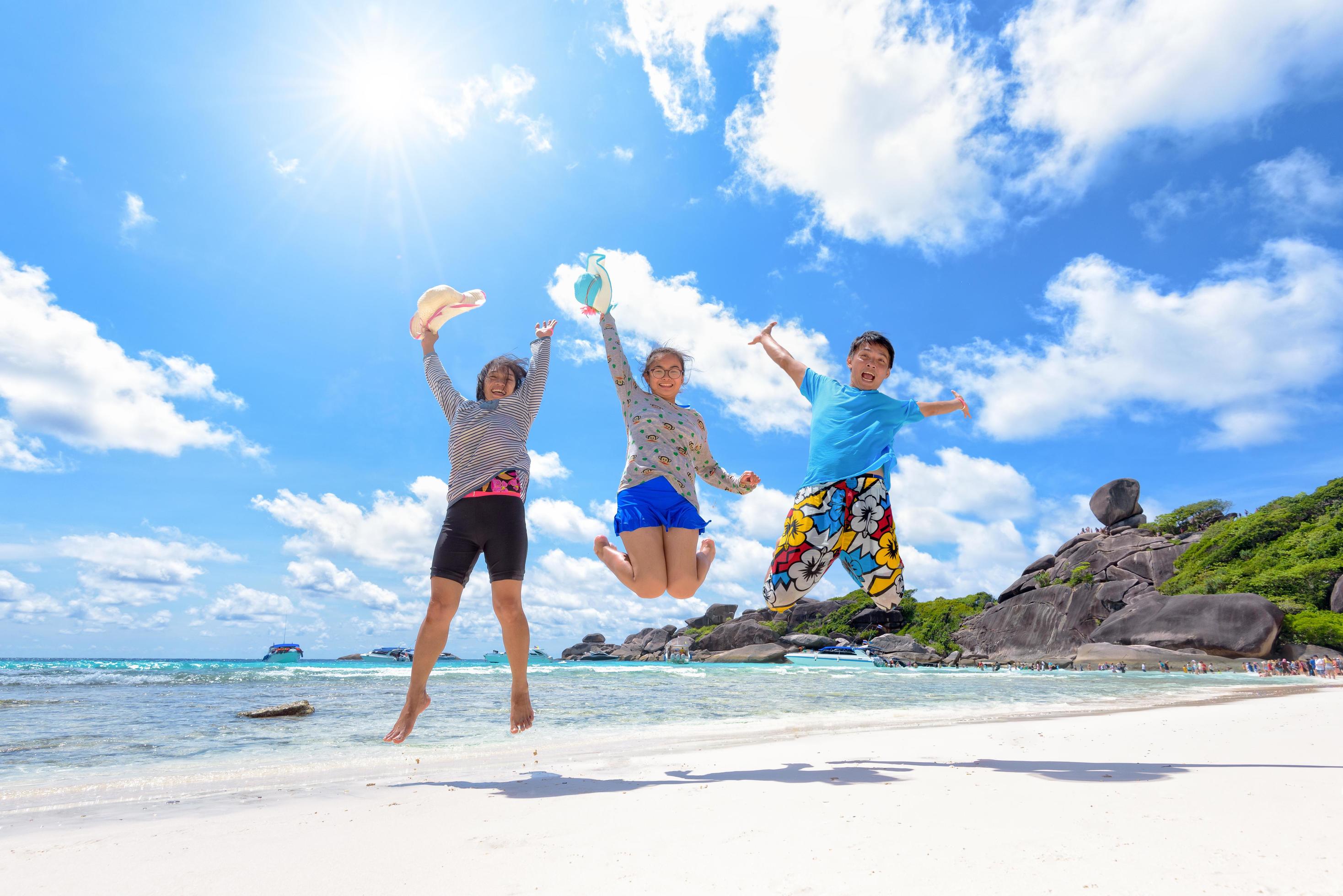 Happy family jumping on beach in Thailand Stock Free