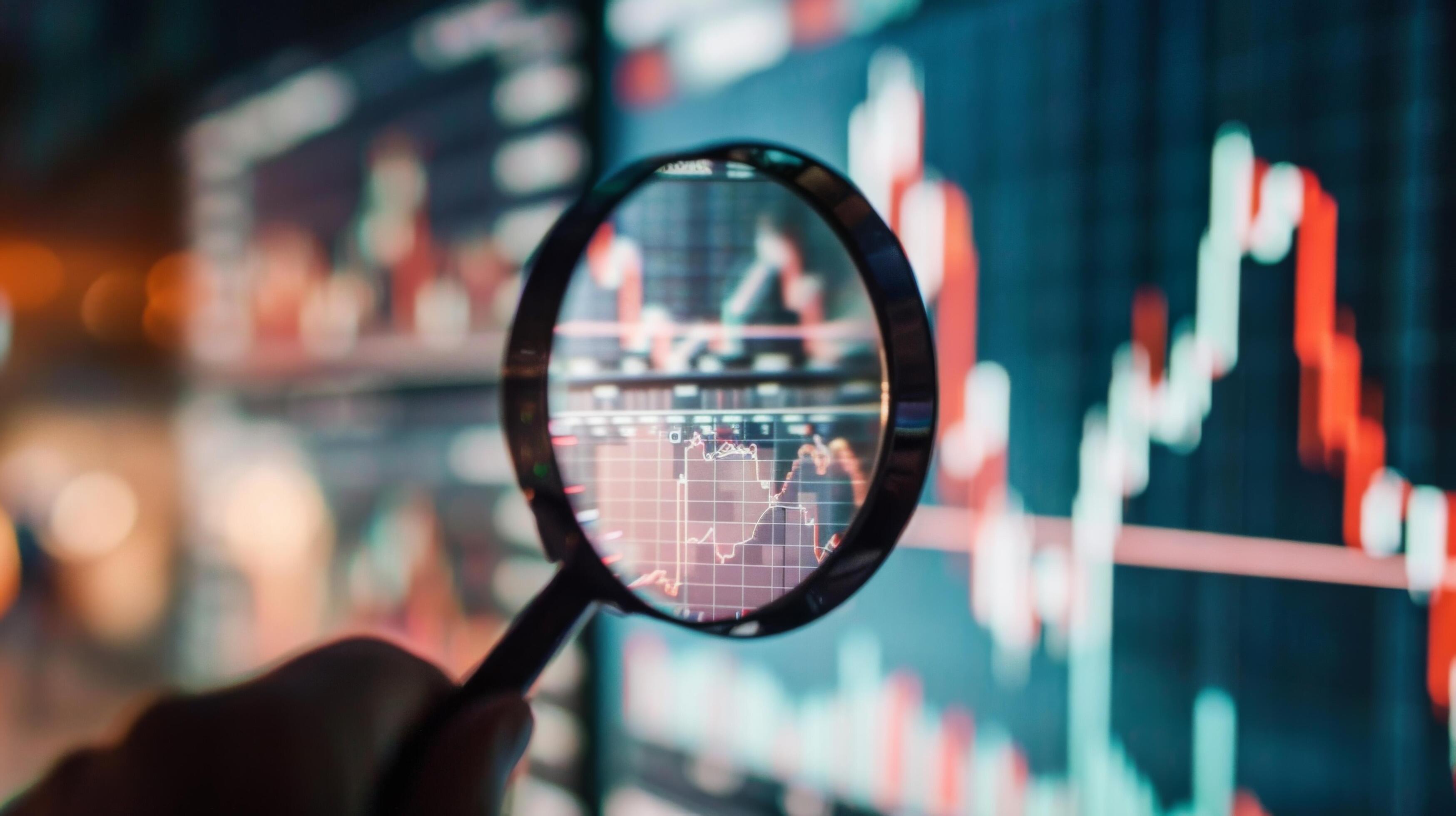 Close-Up of Magnifying Glass Focused on Stock Market Indicators with Blurred Background Stock Free