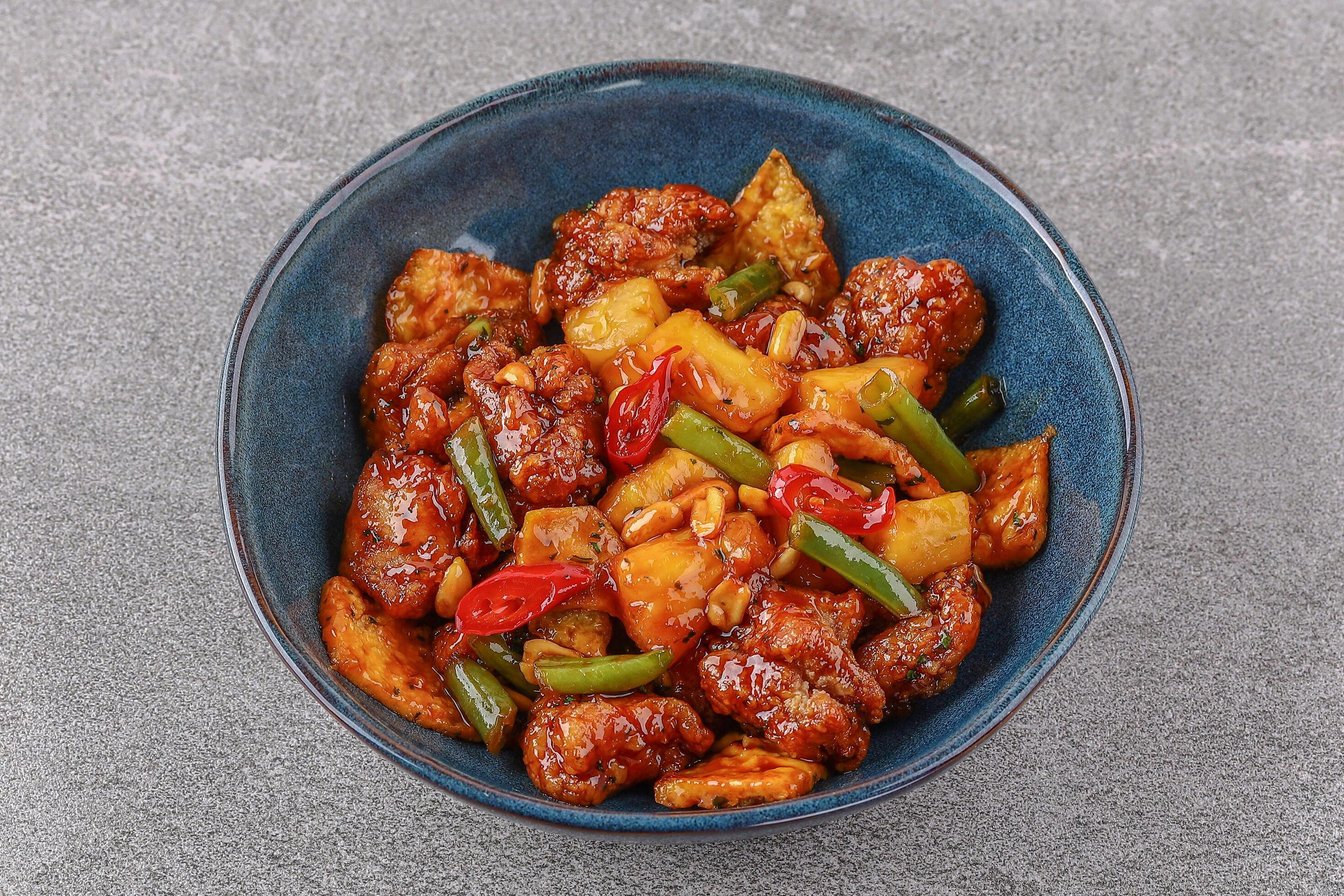 Chicken with pineapple in teriyaki sauce on a stone background studio shooting 3 Stock Free