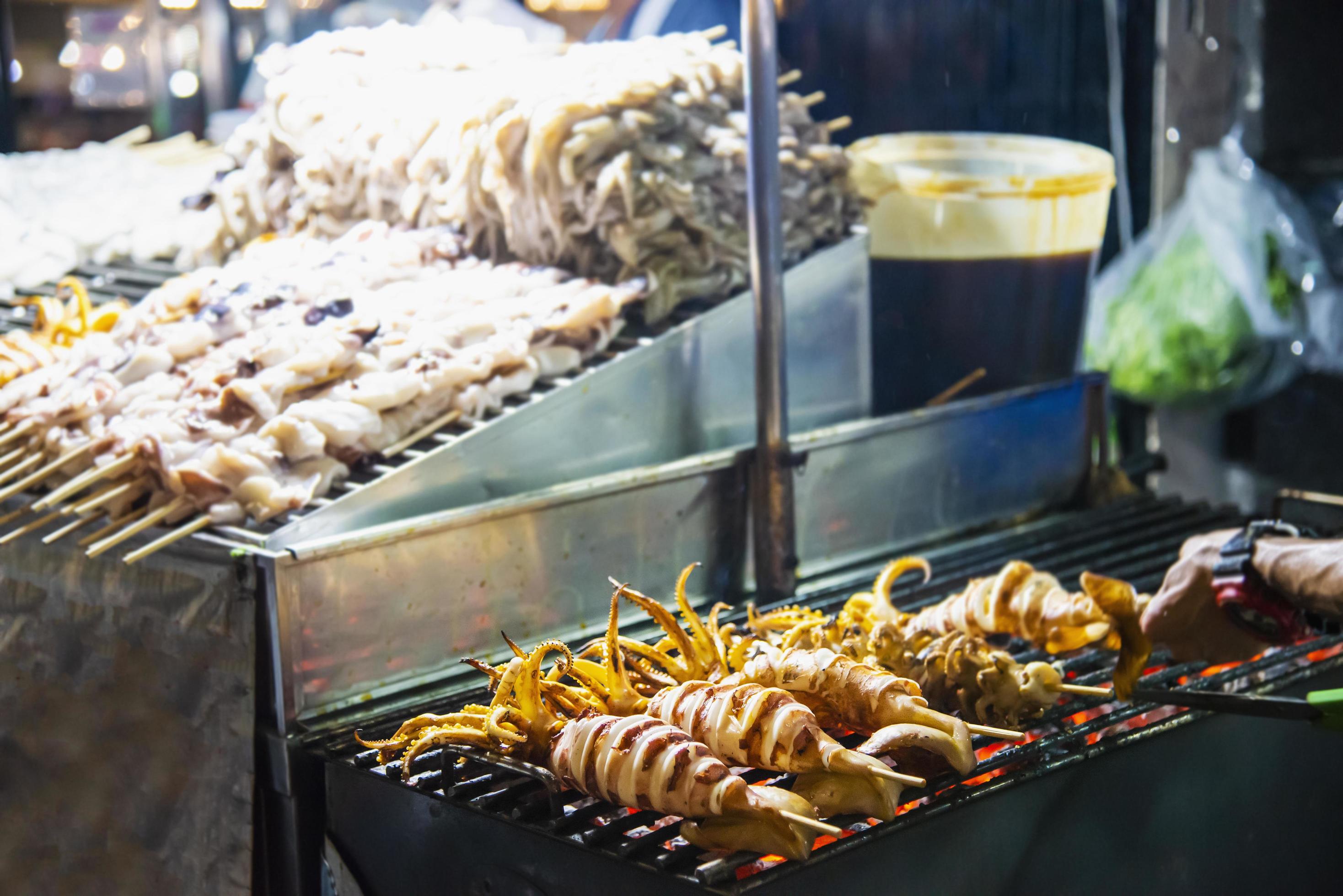 Grilled squid seller in local street food in Yaowarat road famous tourist place Thailand Stock Free