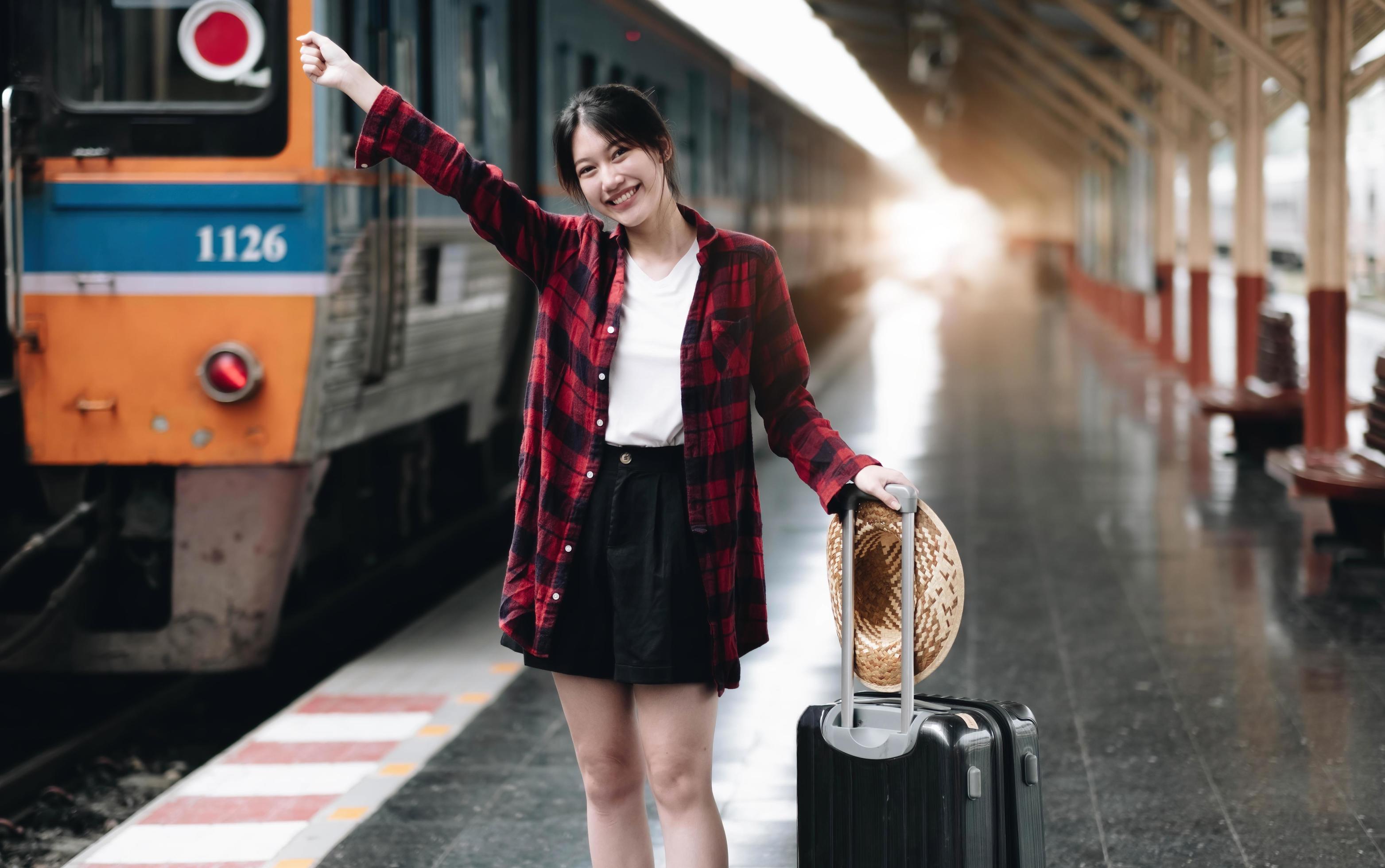 Young traveler woman looking for friend planning trip at train station. Summer and travel lifestyle concept Stock Free