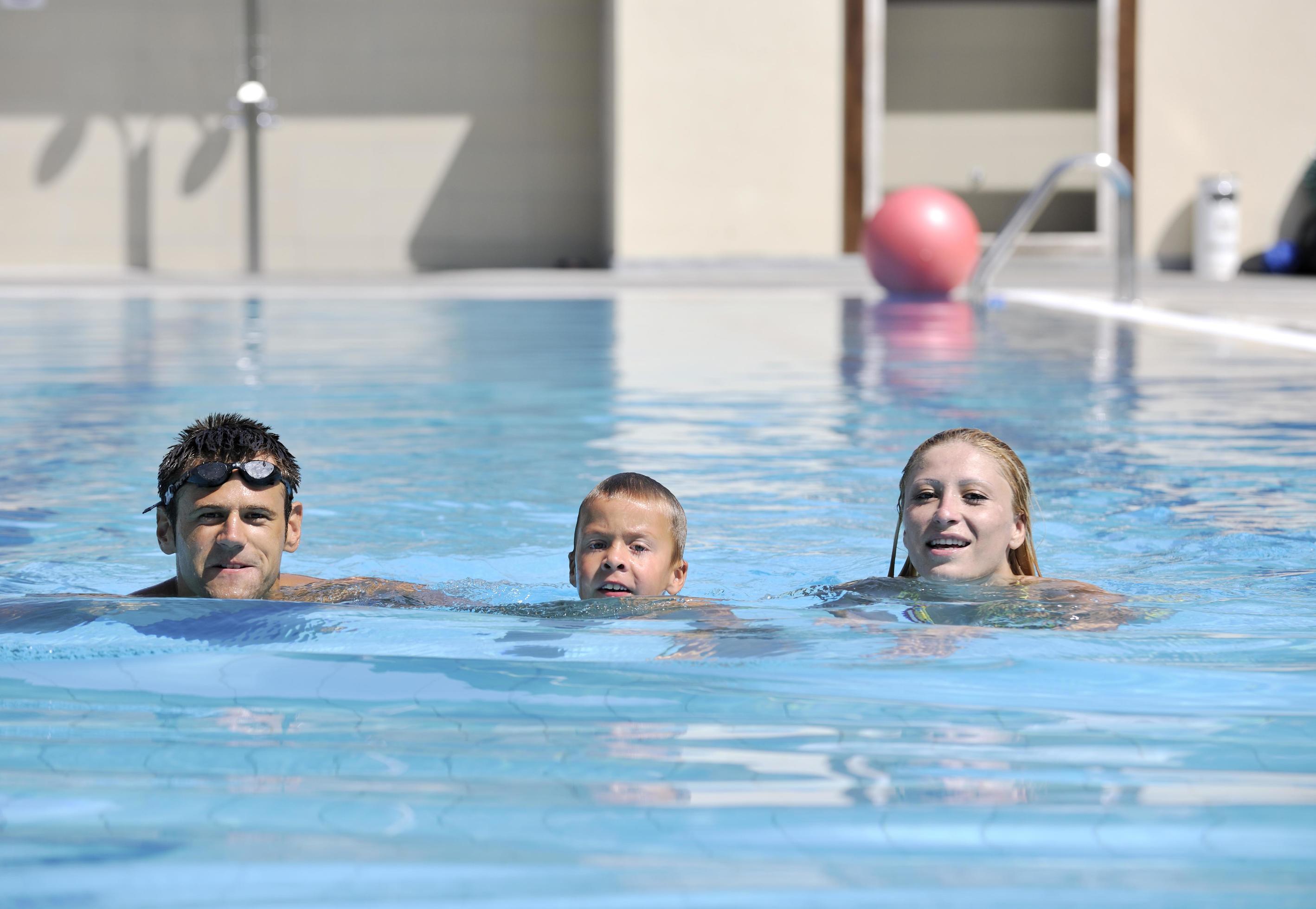 happy young family have fun on swimming pool Stock Free