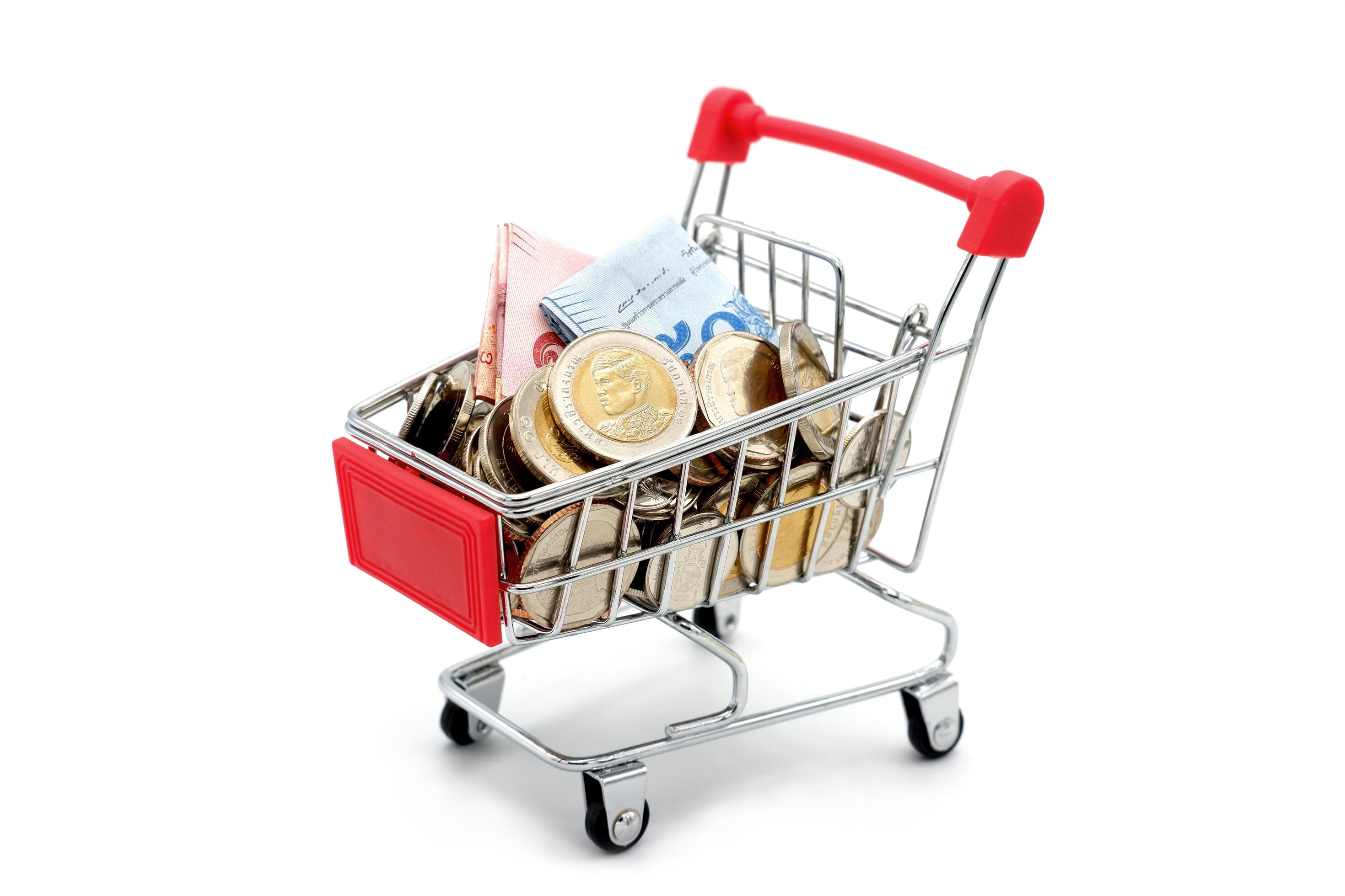 New Thai Baht banknotes and coins in red miniature shopping cart. Business and finance concept. Stock Free