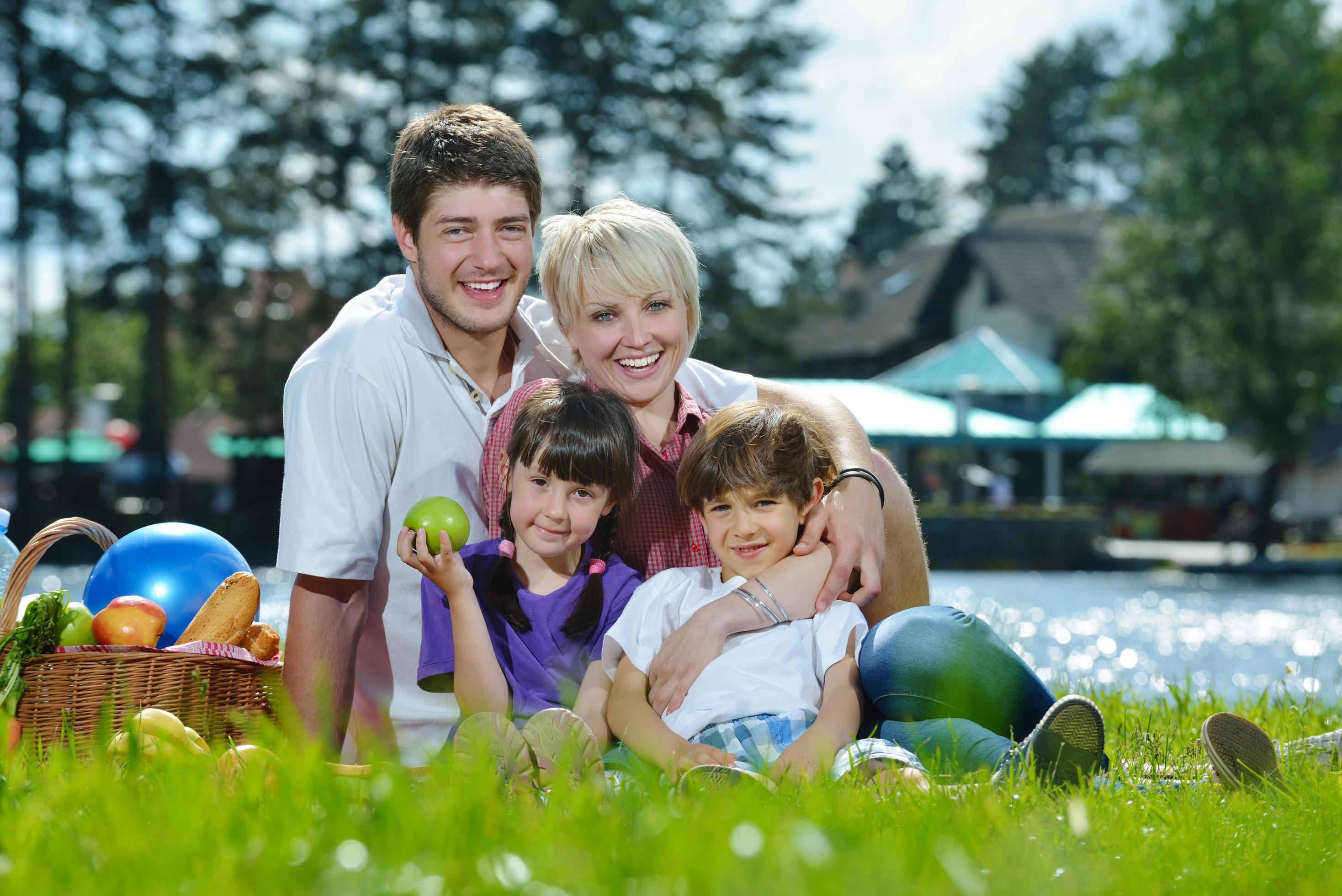 Happy family playing together in a picnic outdoors Stock Free