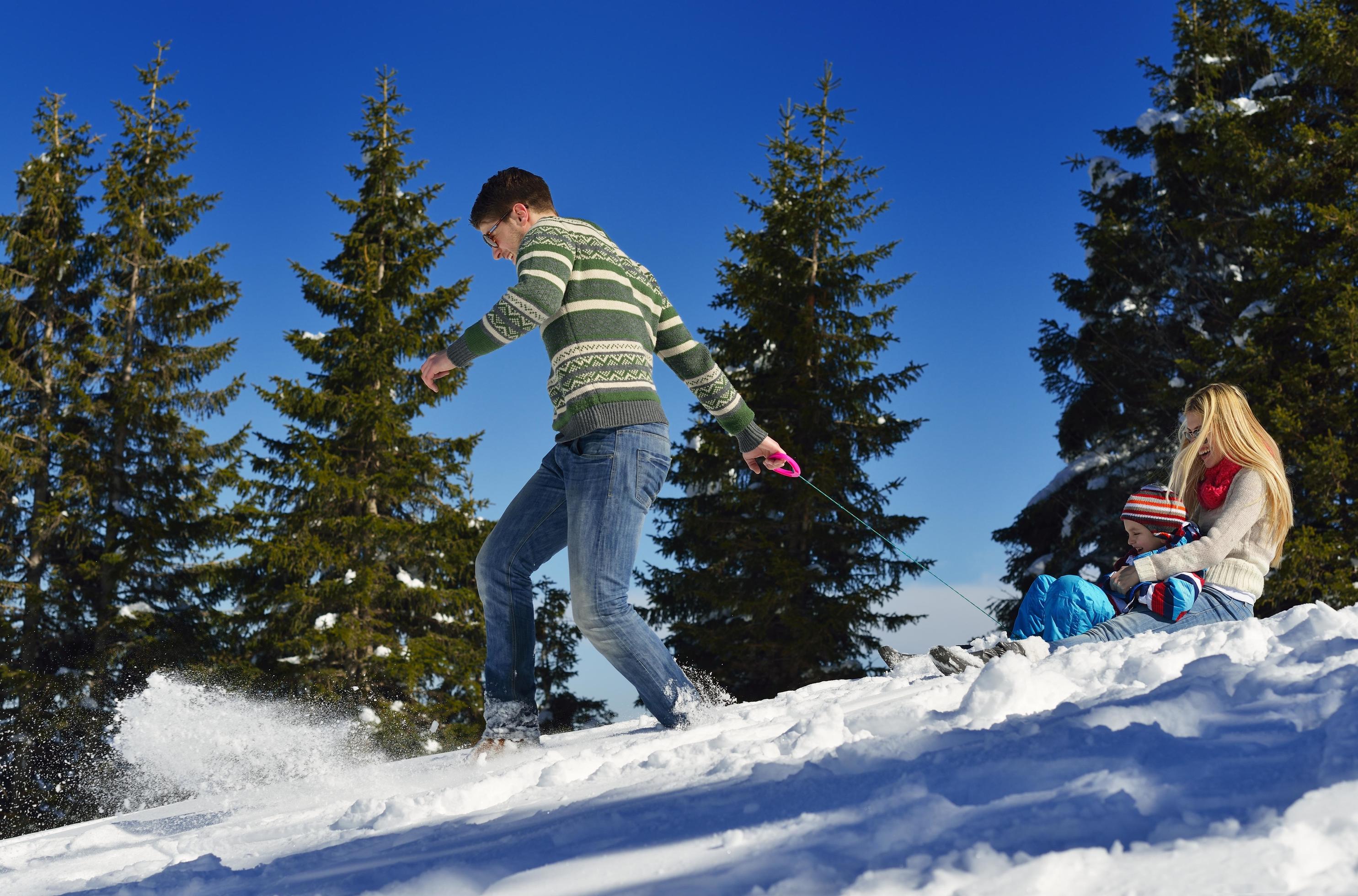 family having fun on fresh snow at winter vacation Stock Free