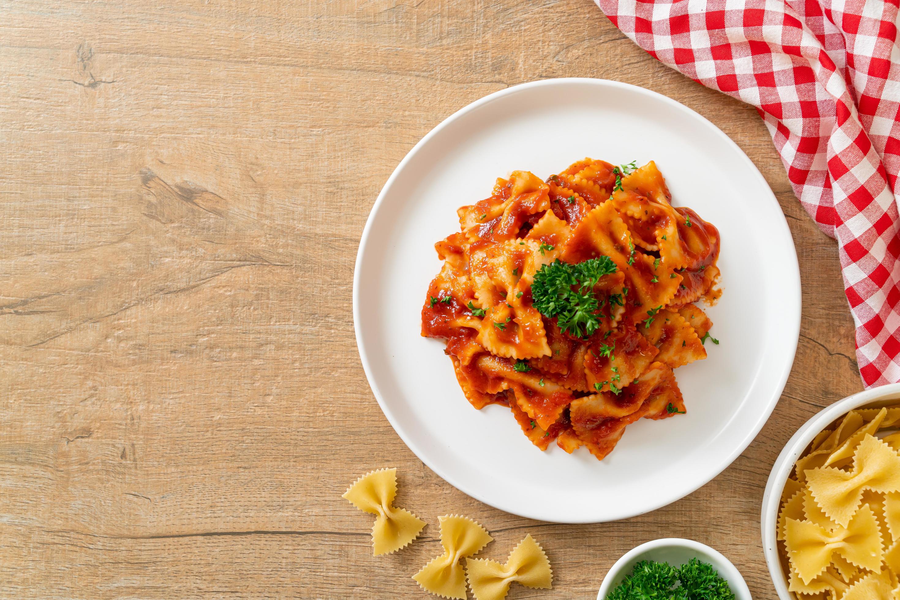 Farfalle pasta in tomato sauce with parsley – Italian food style Stock Free