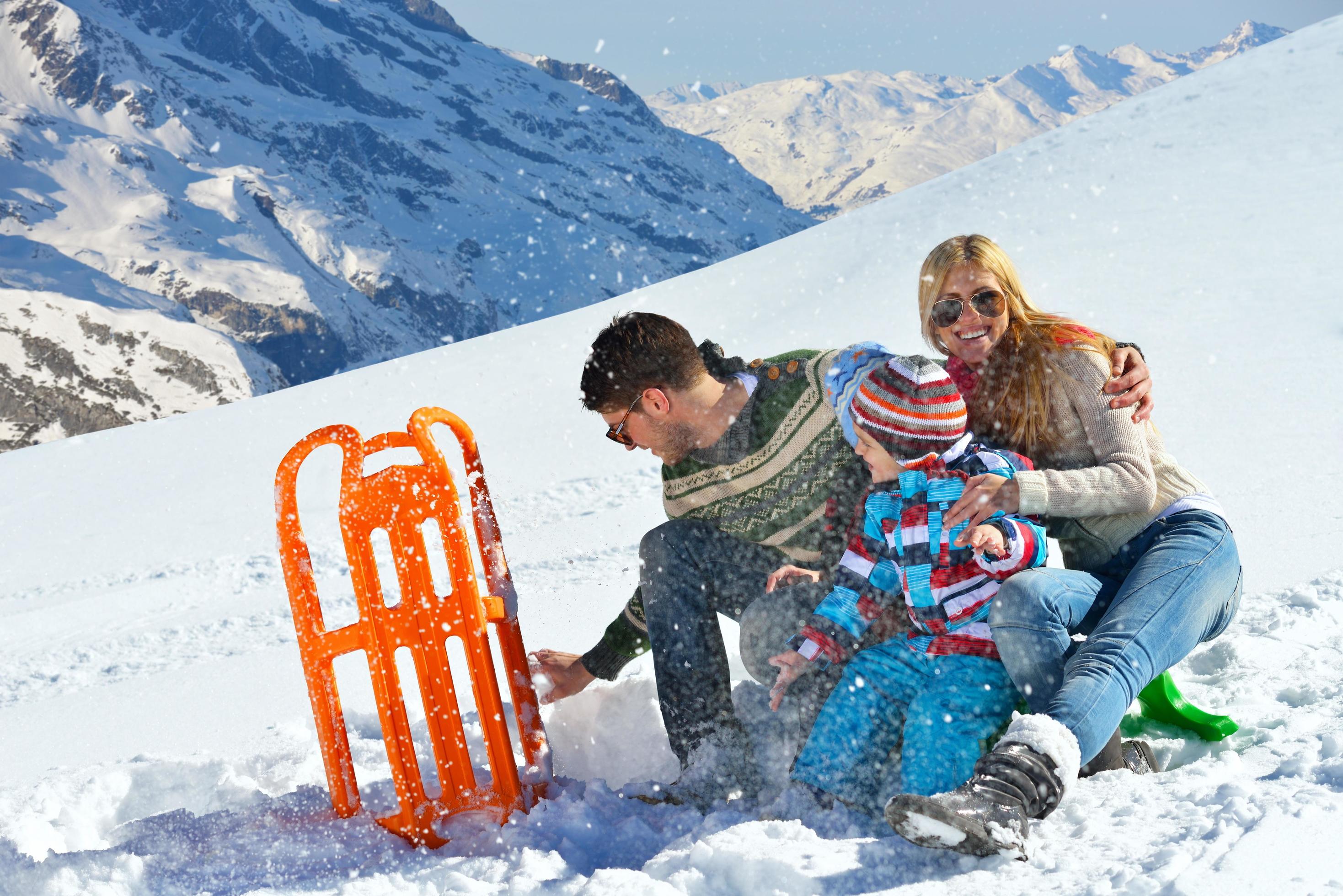 family having fun on fresh snow at winter vacation Stock Free