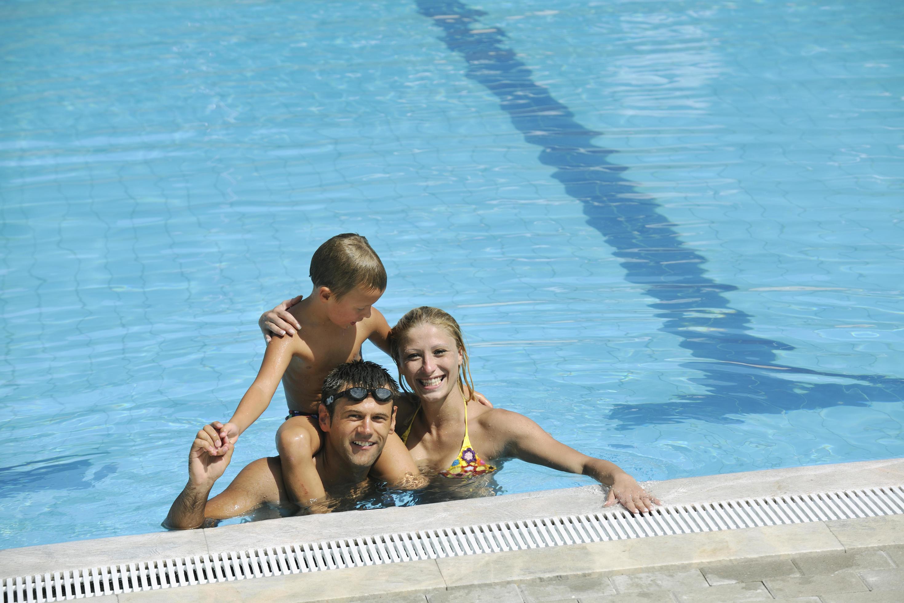 happy young family have fun on swimming pool Stock Free