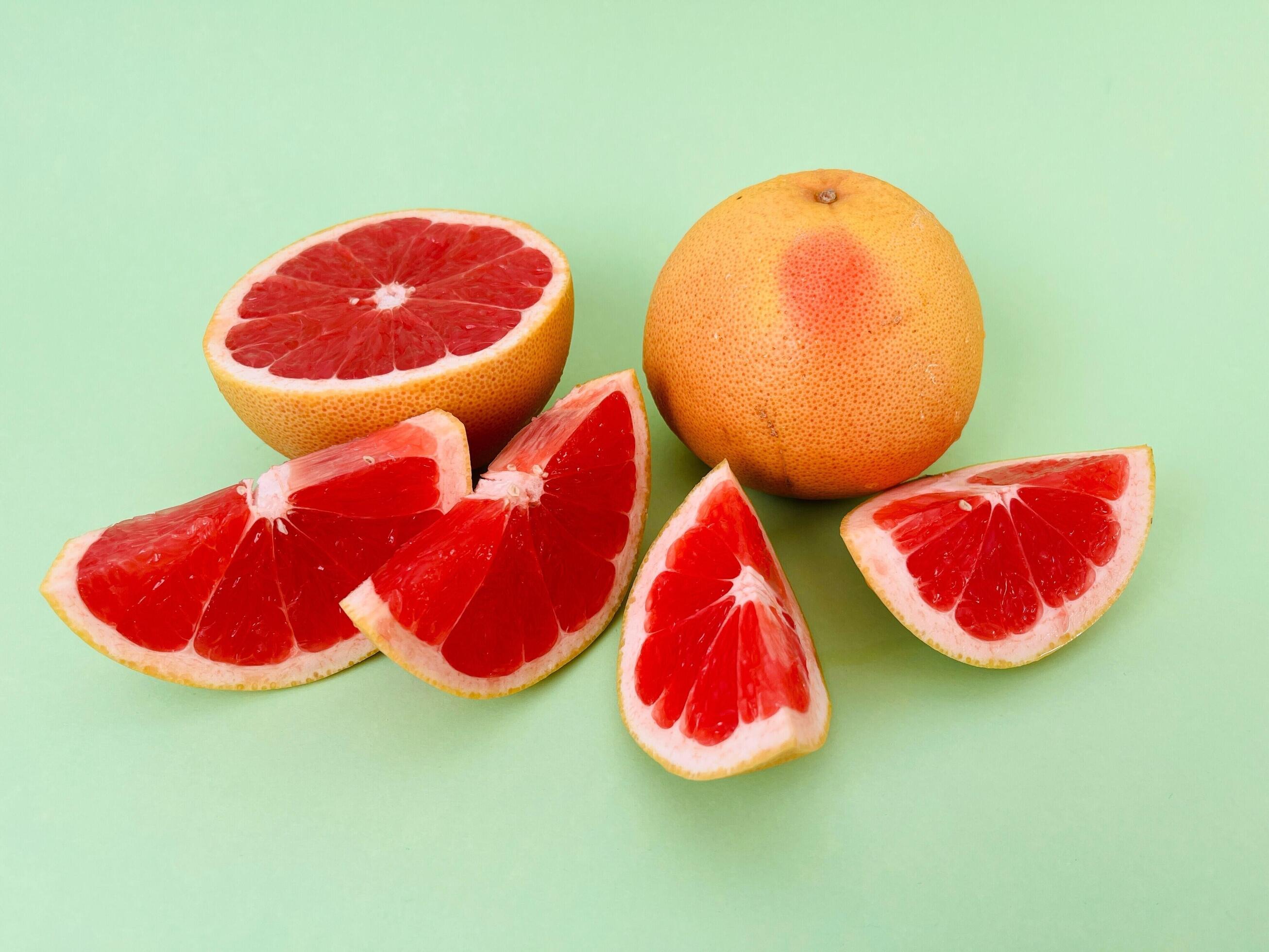 Fresh grapefruit fruit. Grapefruit isolated on green background. Grapefruit with clipping path. Stock Free