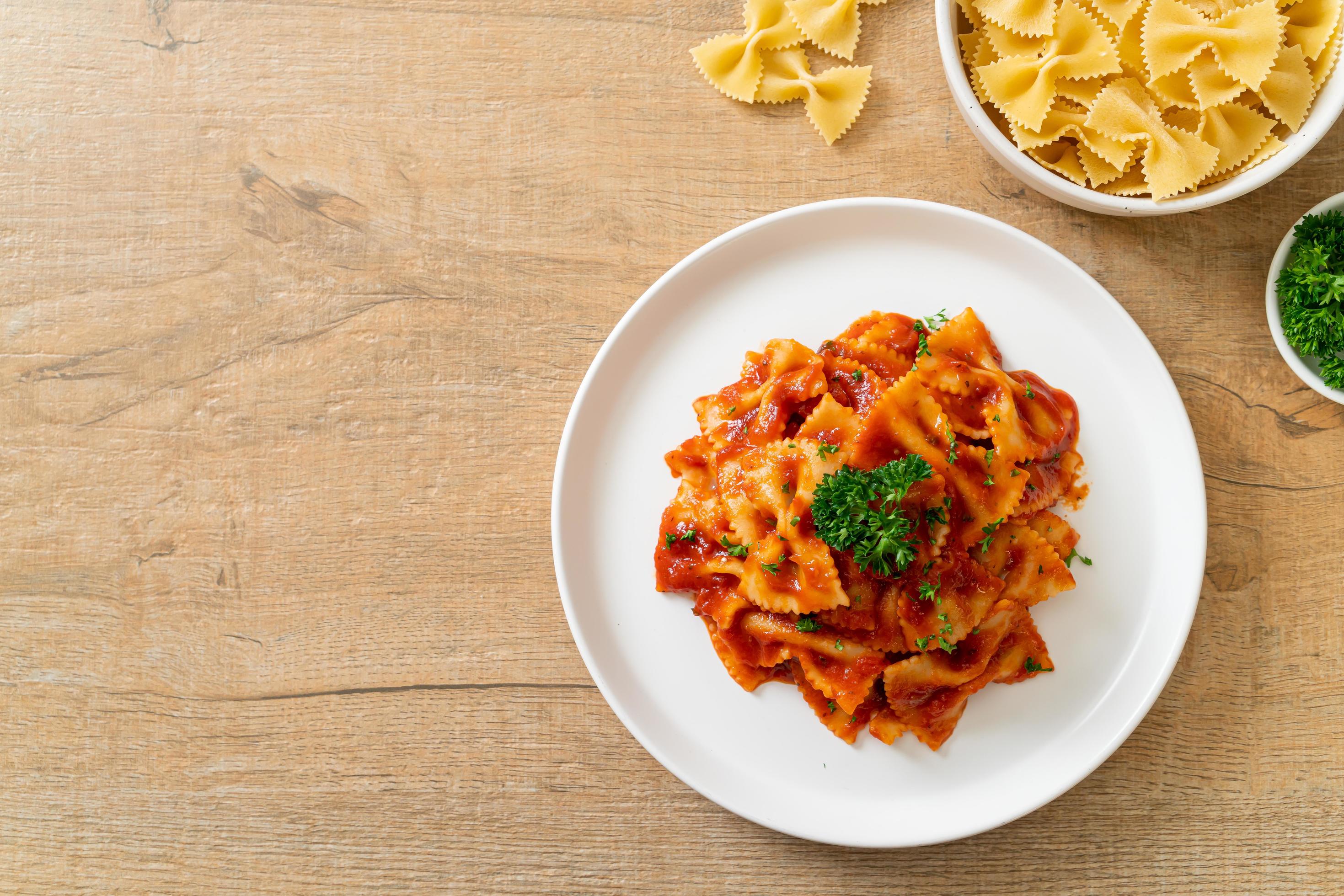 Farfalle pasta in tomato sauce with parsley – Italian food style Stock Free