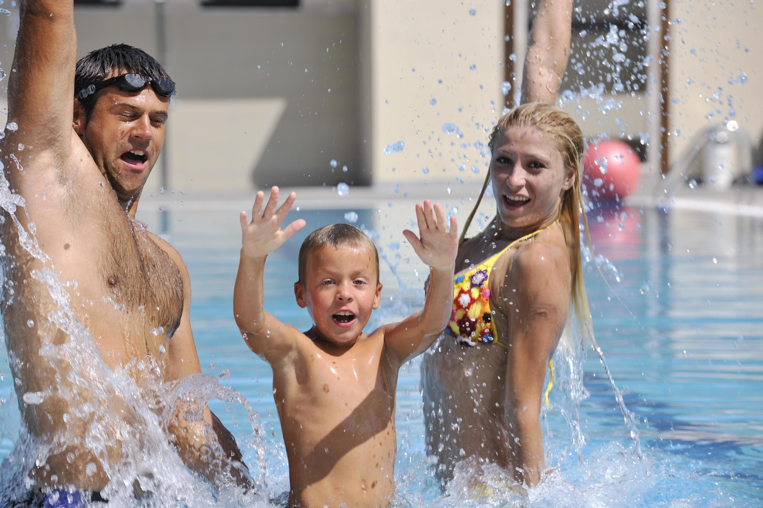 happy young family have fun on swimming pool Stock Free