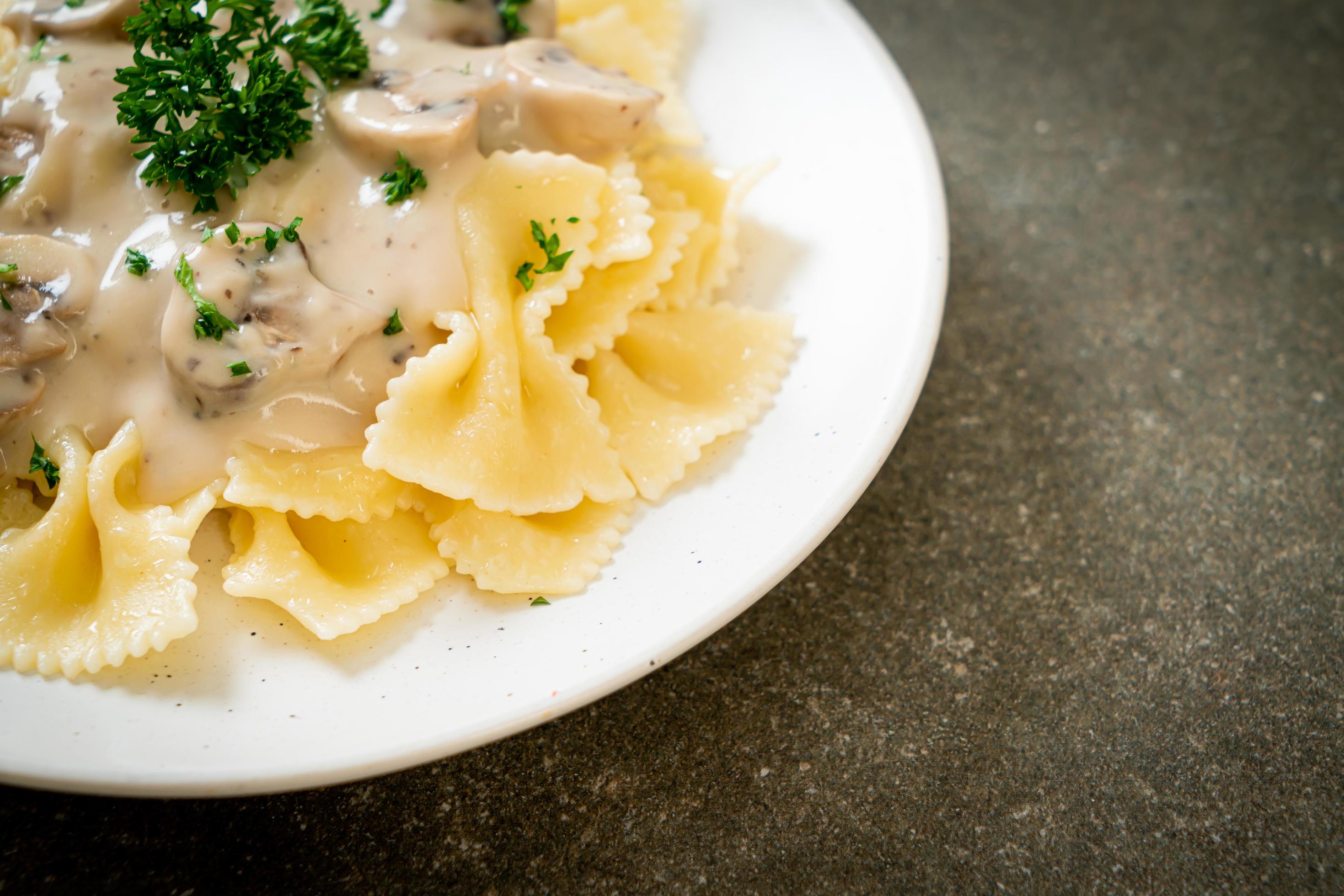 Farfalle pasta with mushroom white cream sauce – Italian food style Stock Free